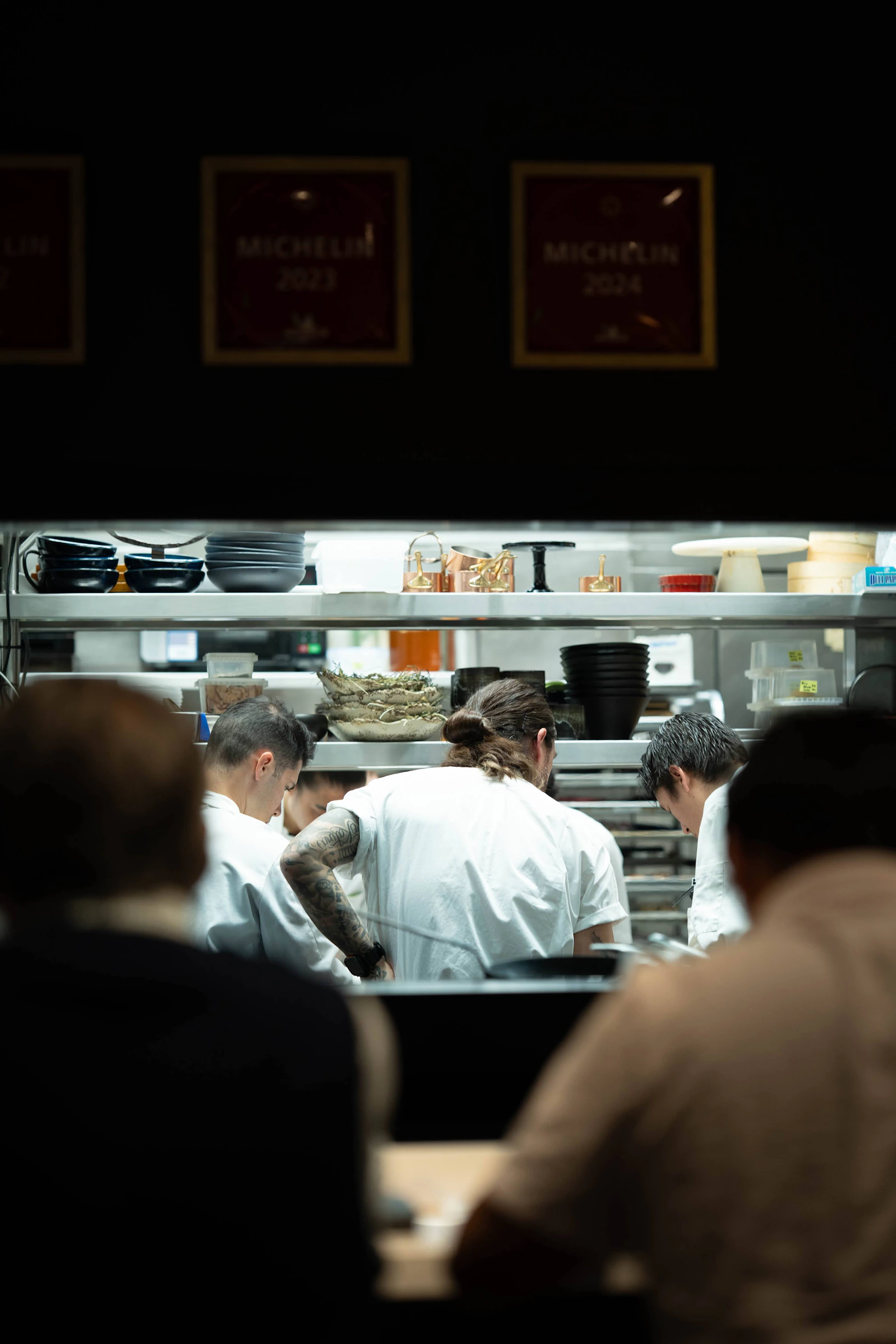 Three chefs working together in a busy restaurant kitchen
