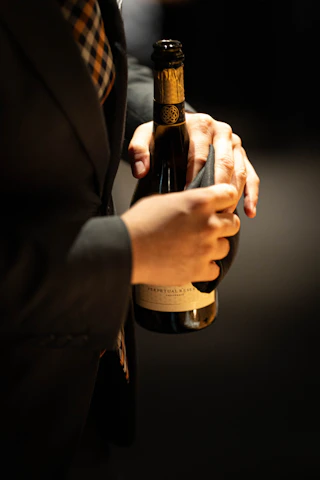 Man in suit holding a bottle with cloth