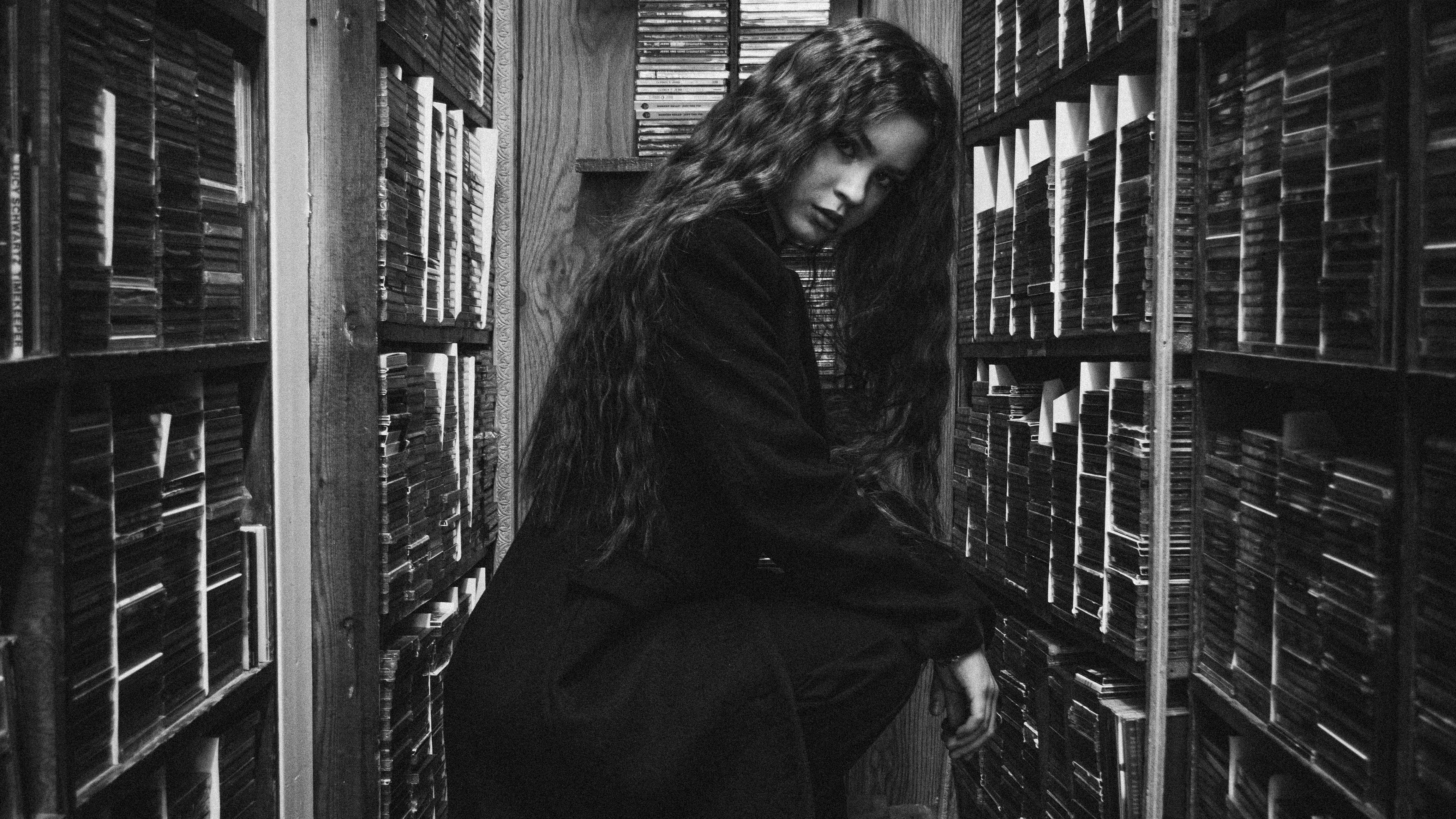 Young woman in a library with many books
