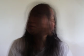 Blurred portrait of a person against a white background