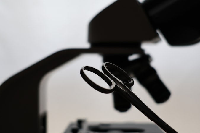 Microscope and scissors against a bright background