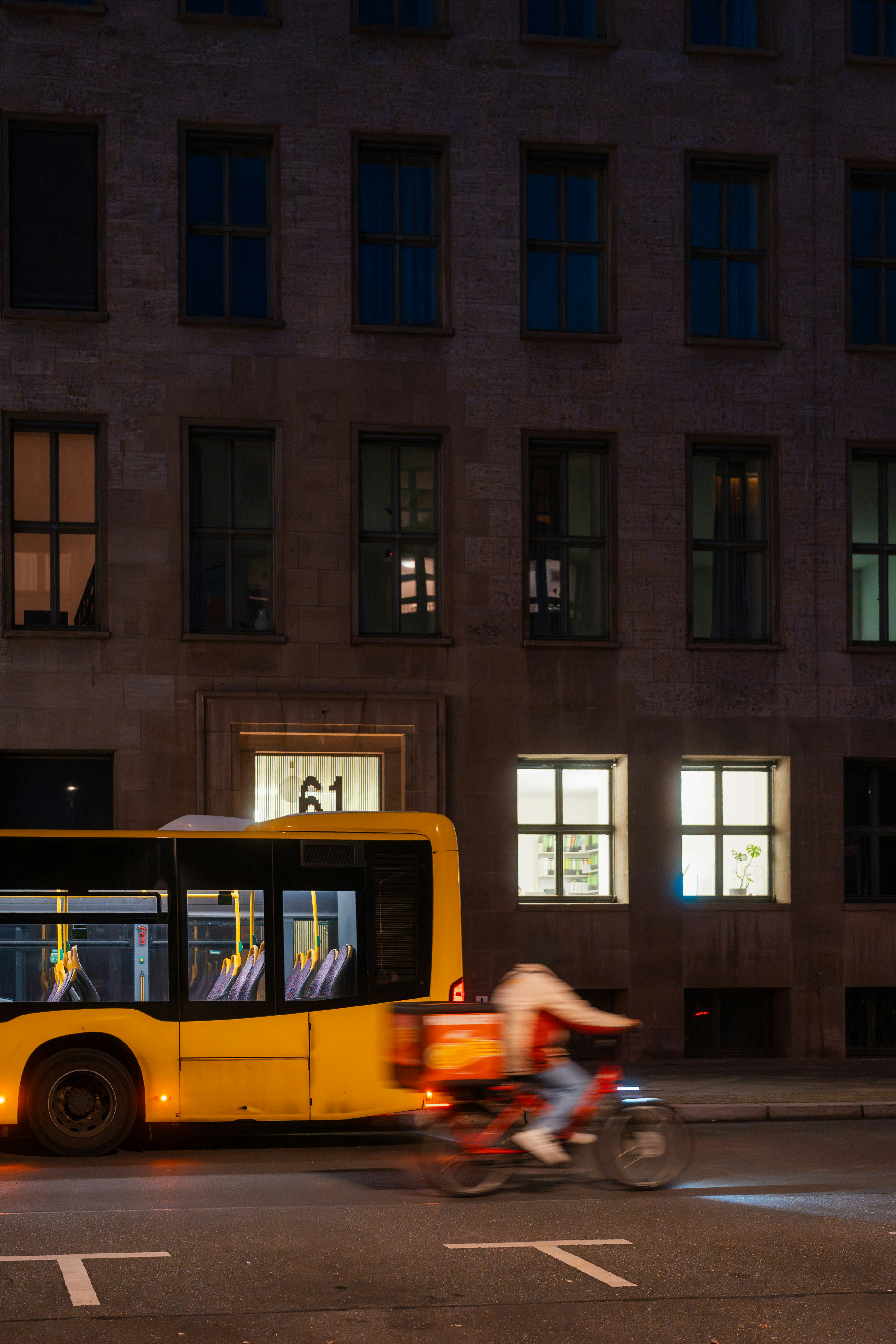 Yellow bus and cyclist at night