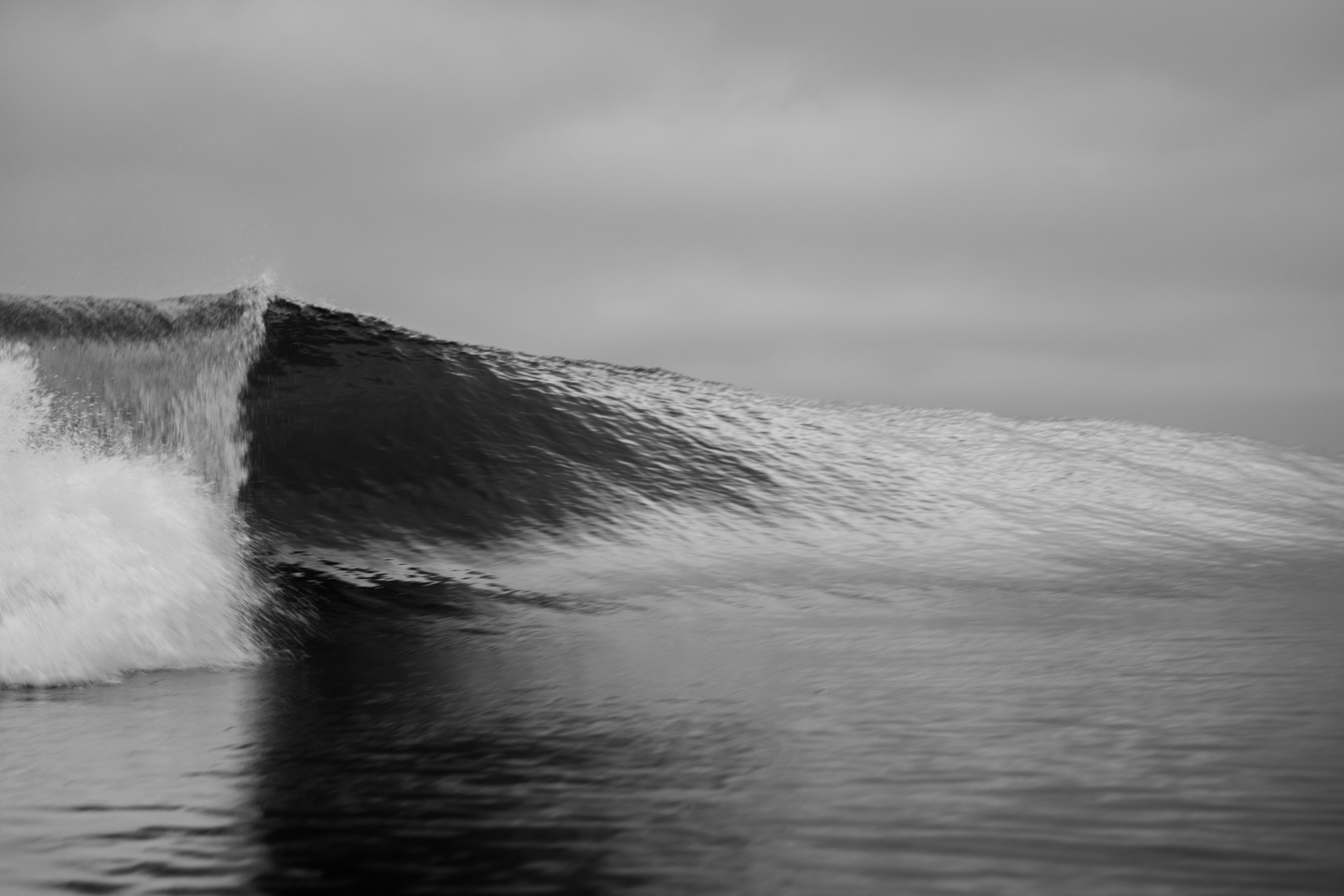 A breaking ocean wave in black and white.