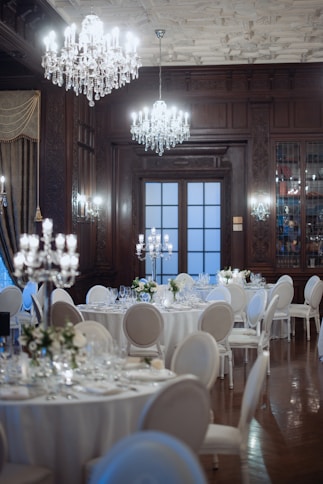 Elegant dining room with round tables and chandeliers.