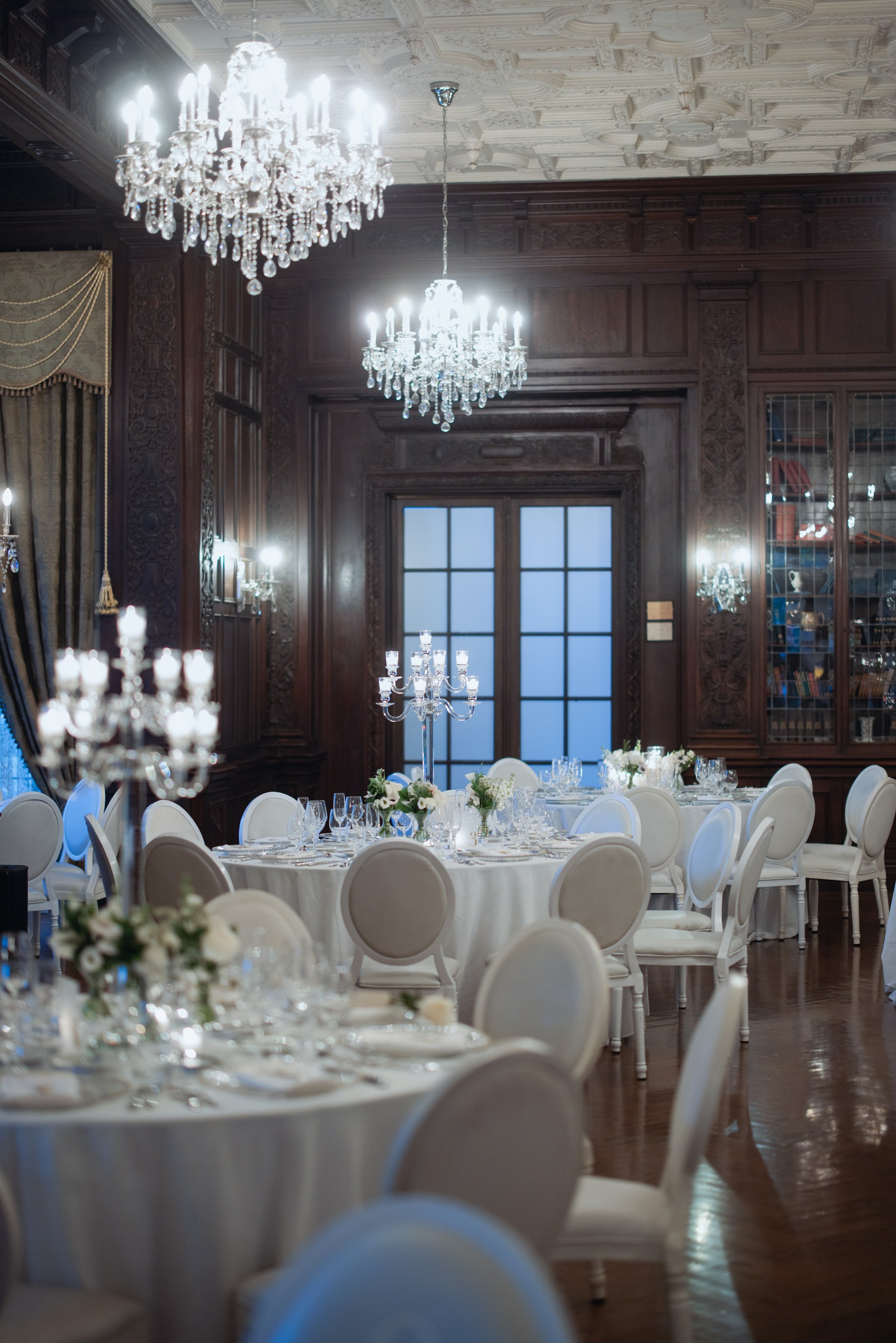Elegant dining room with round tables and chandeliers.