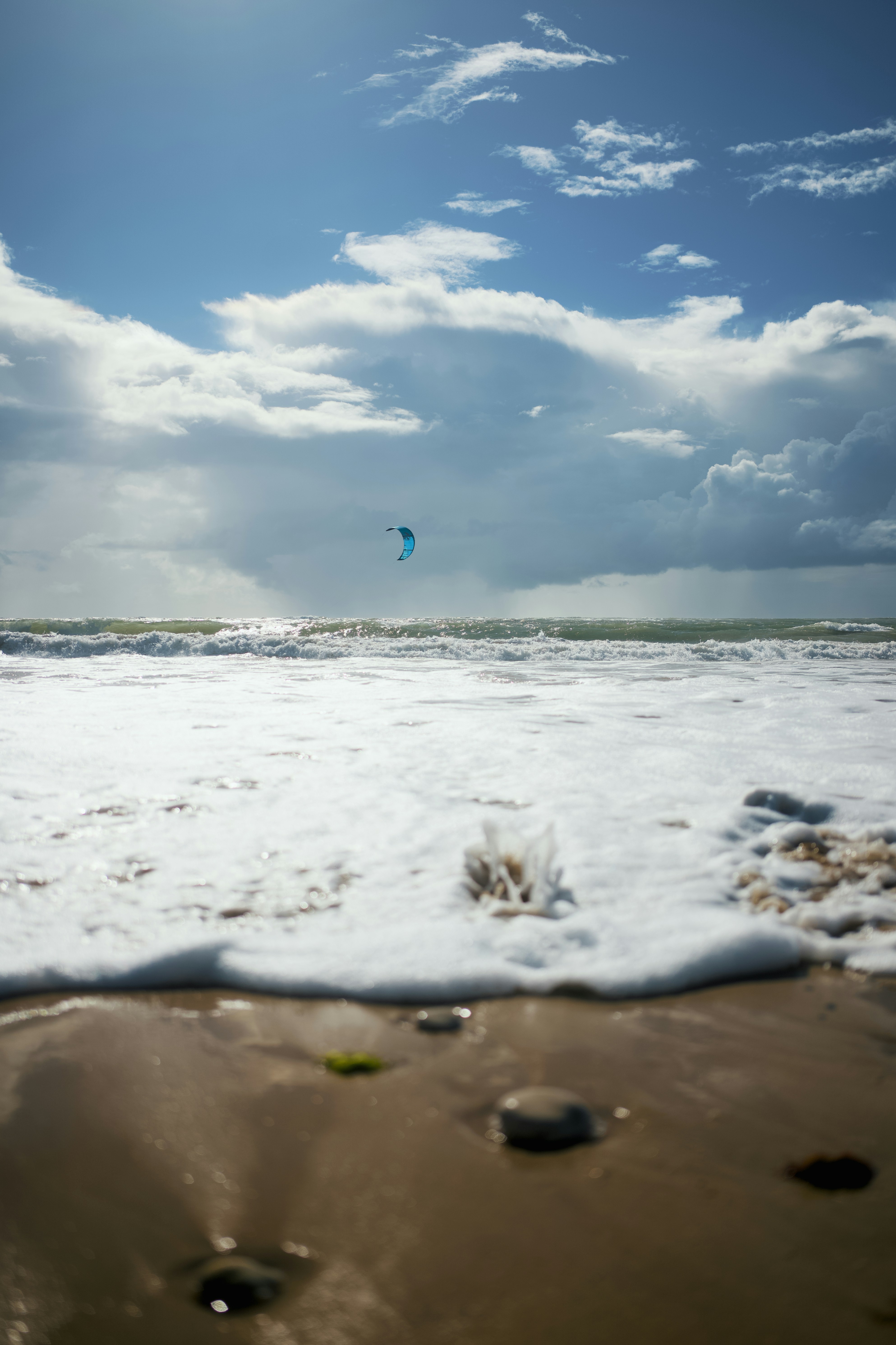 Kitesurfer reitet Wellen unter bewölktem Himmel