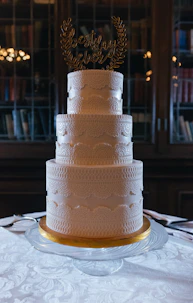 Elegant white tiered wedding cake with topper