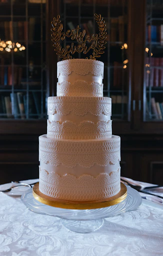 Elegant white tiered wedding cake with topper