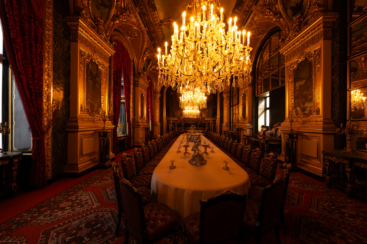 Ornate hall interior with chandeliers above a long dining table