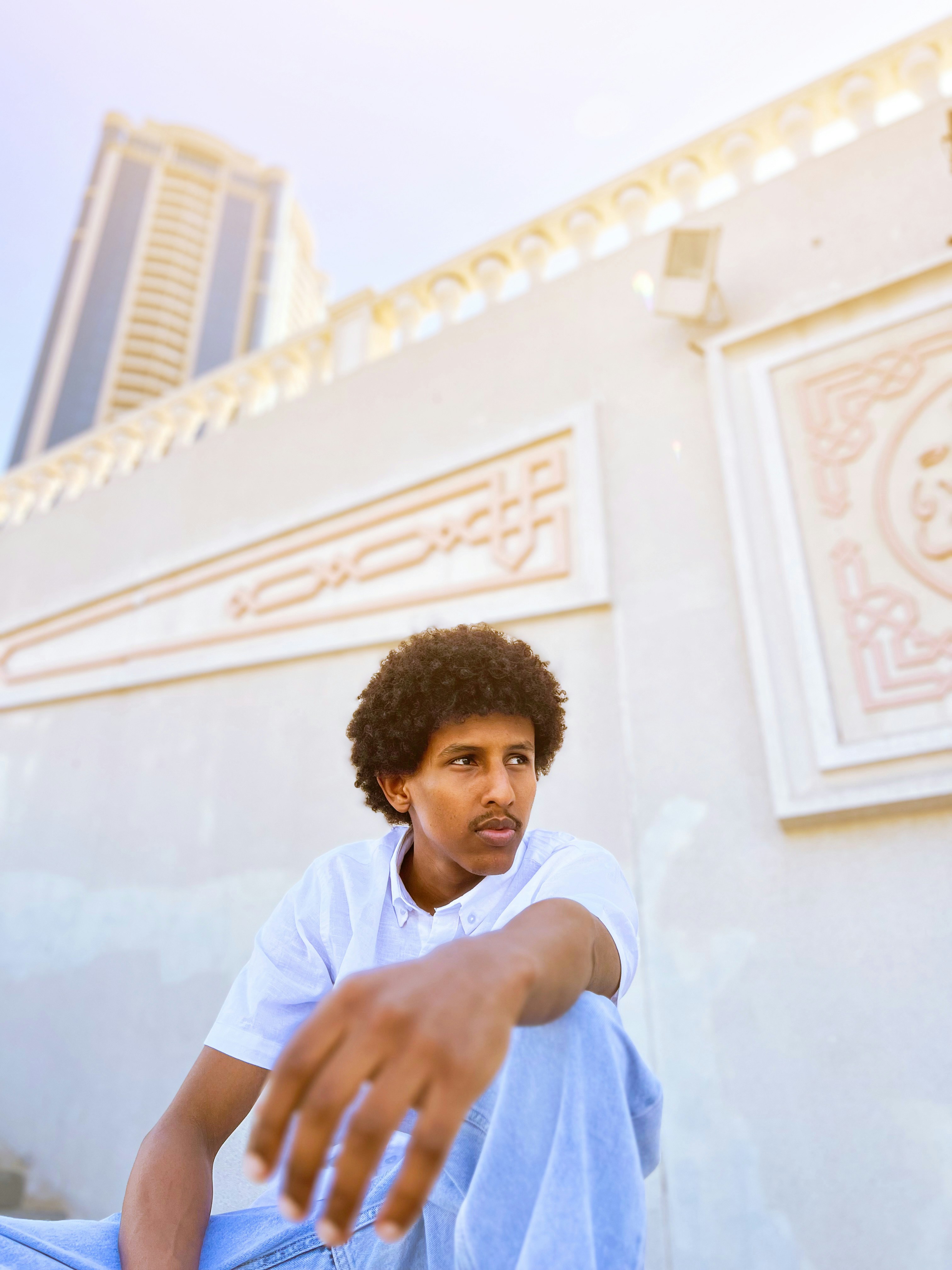 Young man in white shirt and jeans looking away