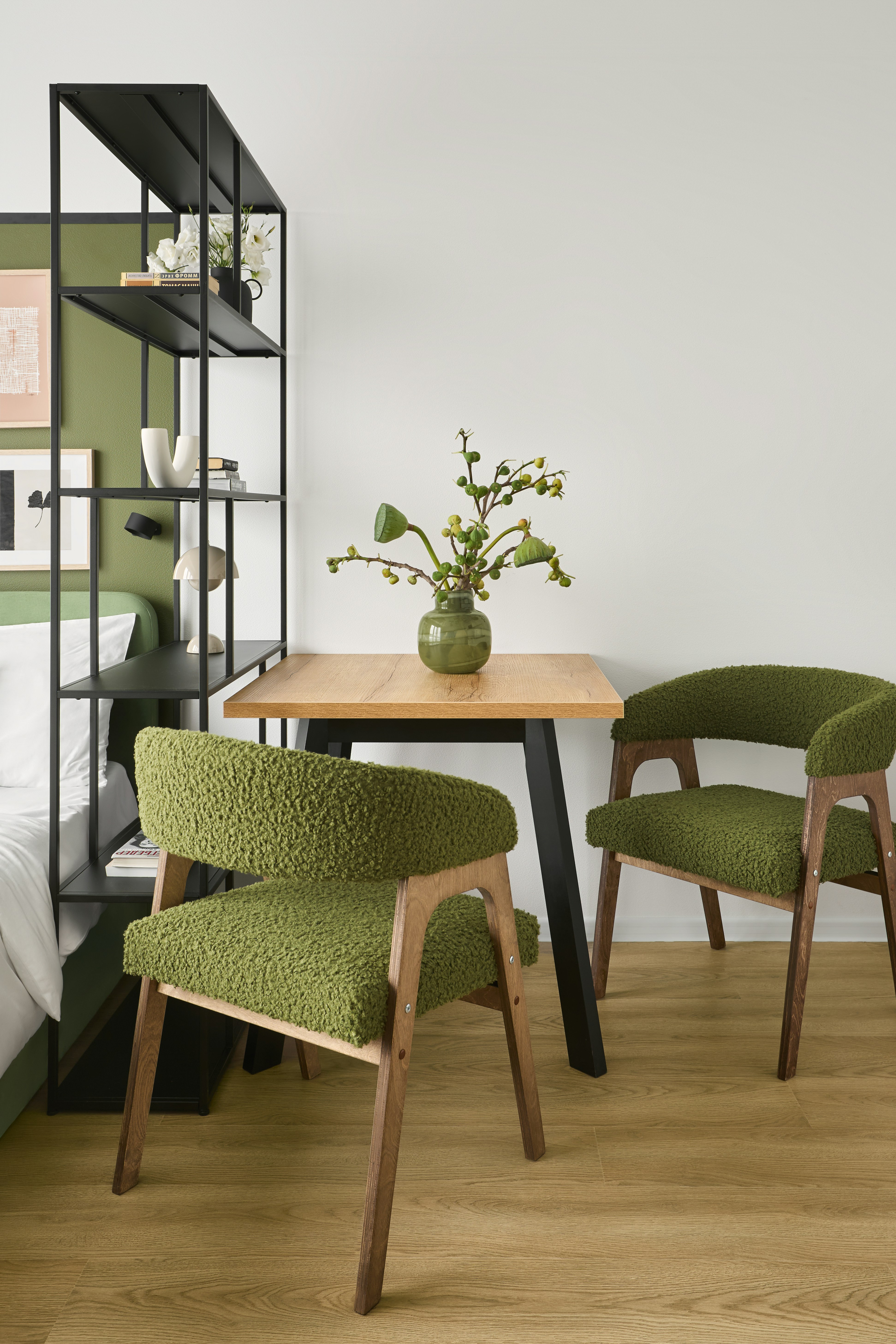 Two green chairs at a small wooden table.