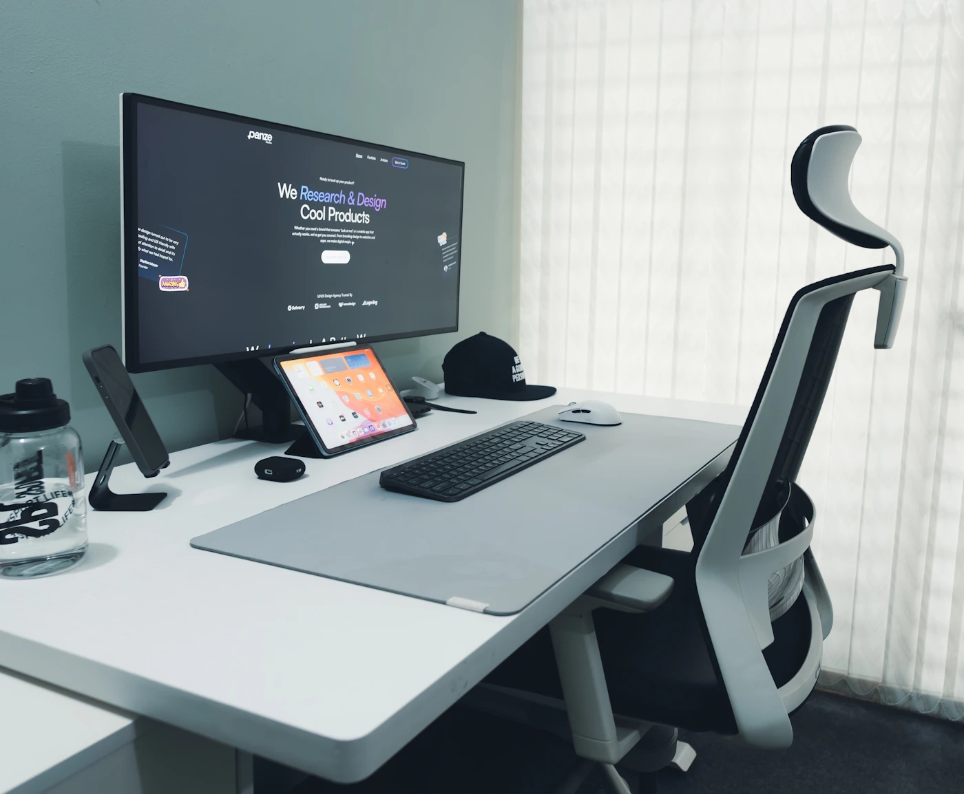 Clean desk setup with computer monitor, keyboard and ergonomic office chair