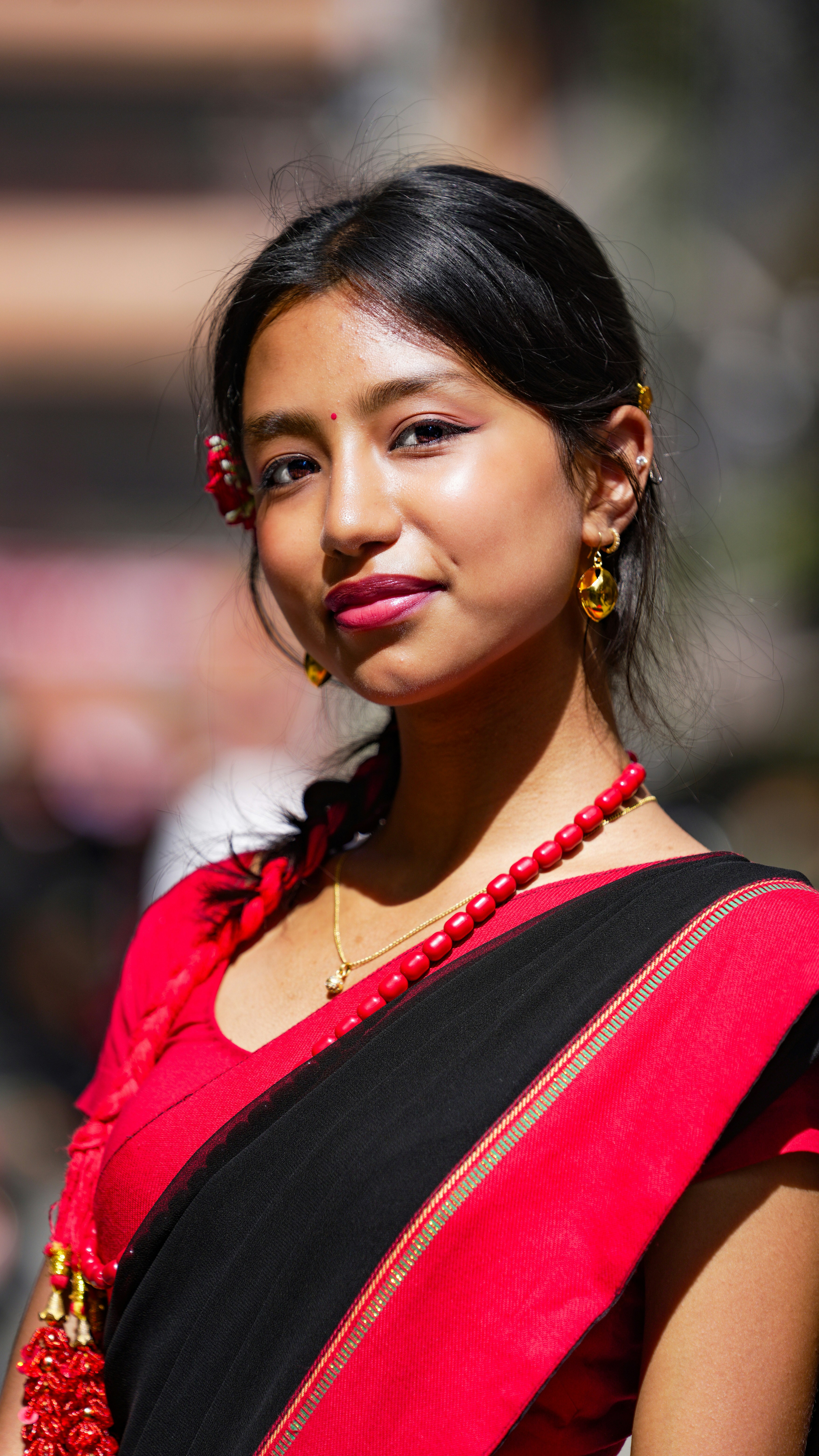 Young woman in traditional red and black attire.