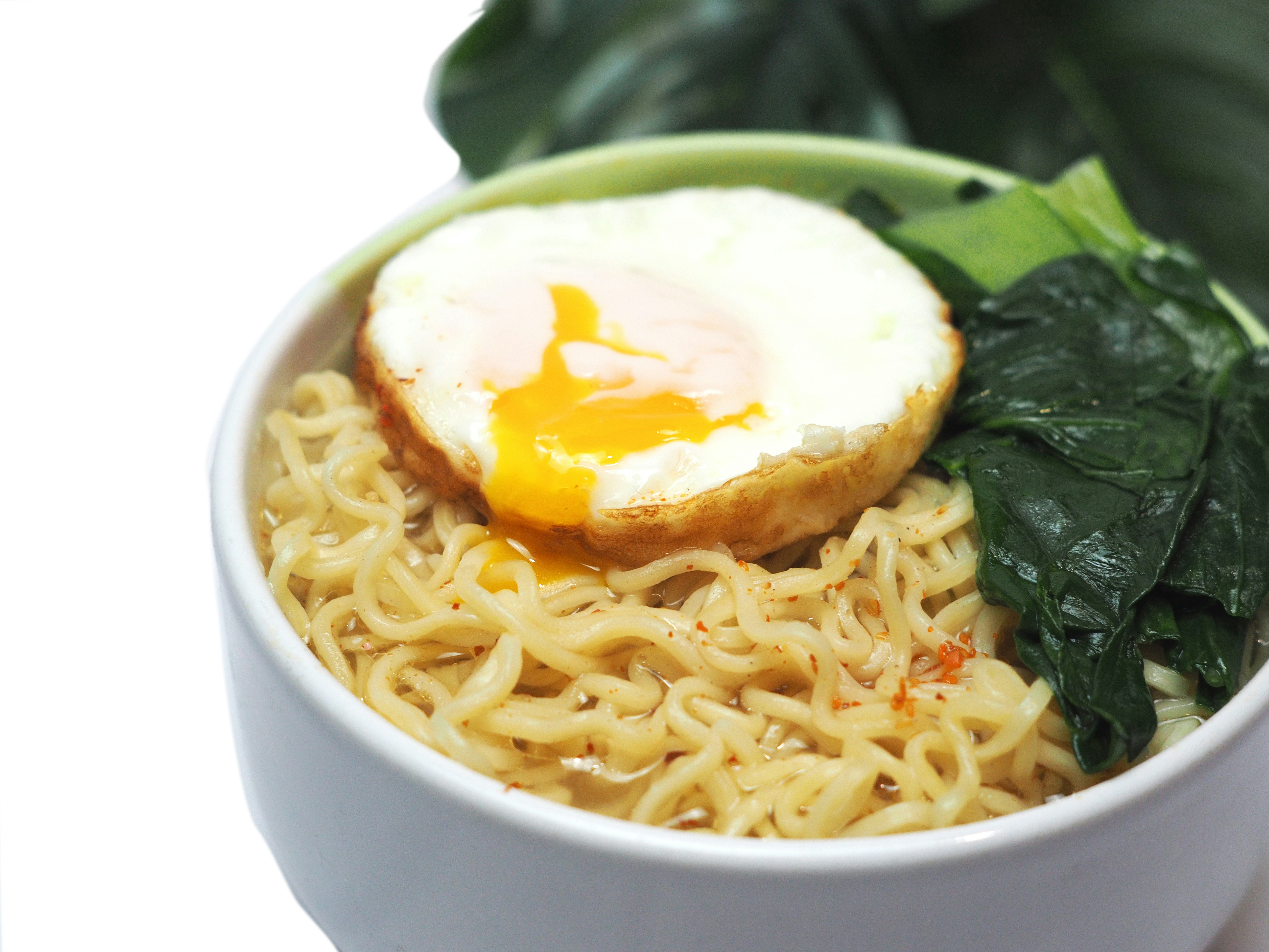 Bowl of noodles with fried egg and greens