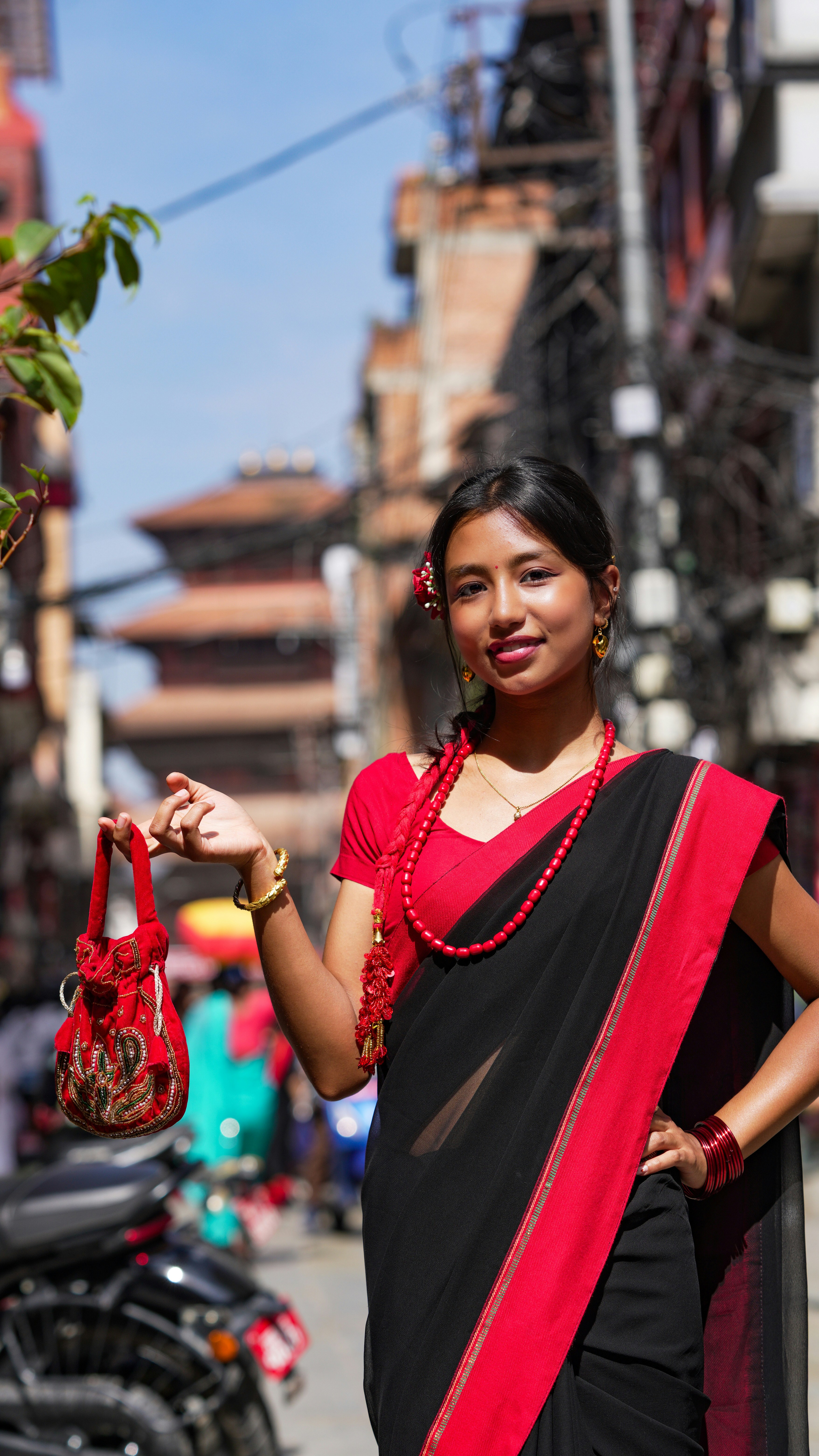 Young woman in traditional attire holding a small purse.