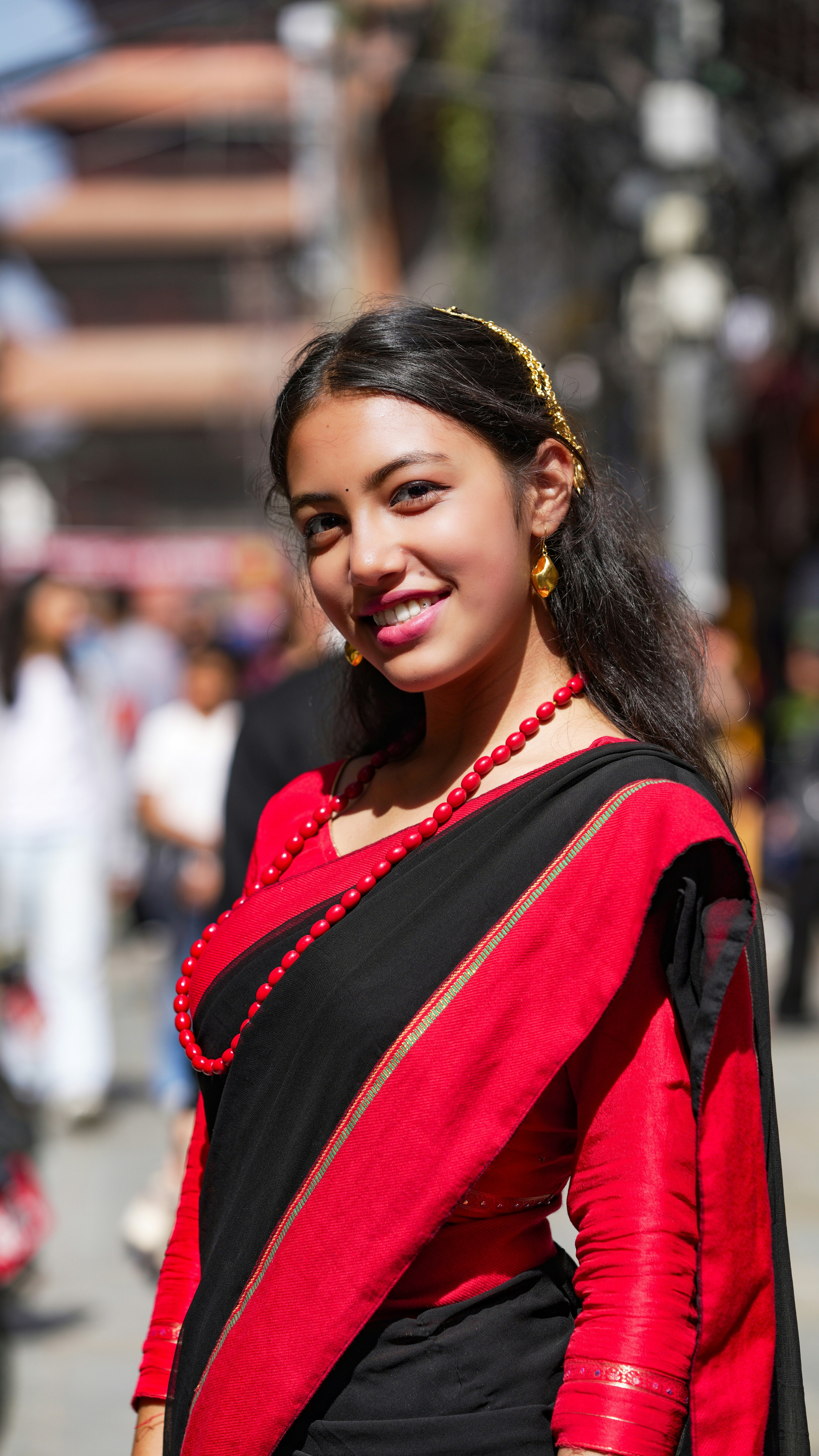 Young woman in traditional red and black sari smiling
