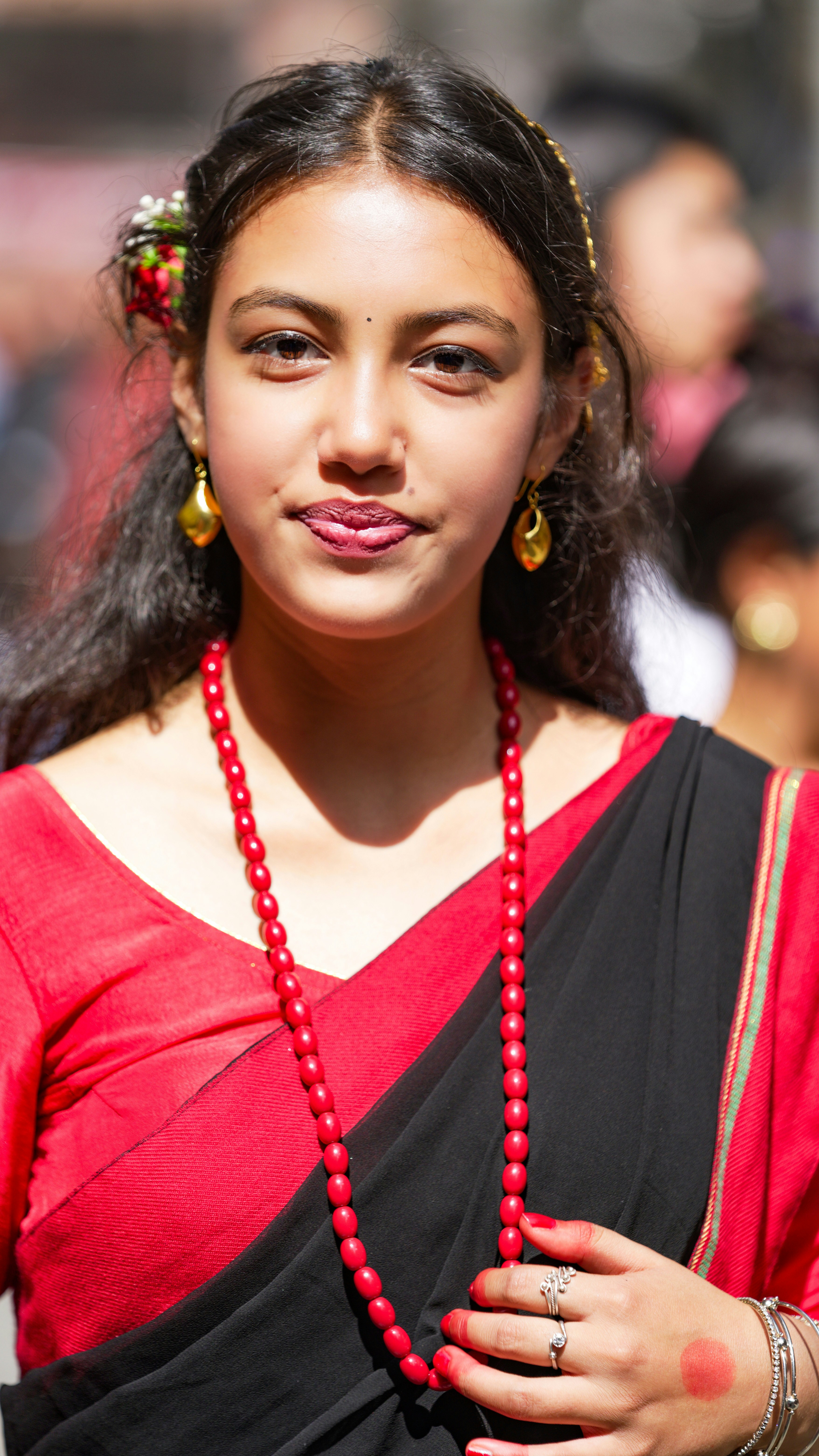 Young woman in traditional red and black attire.