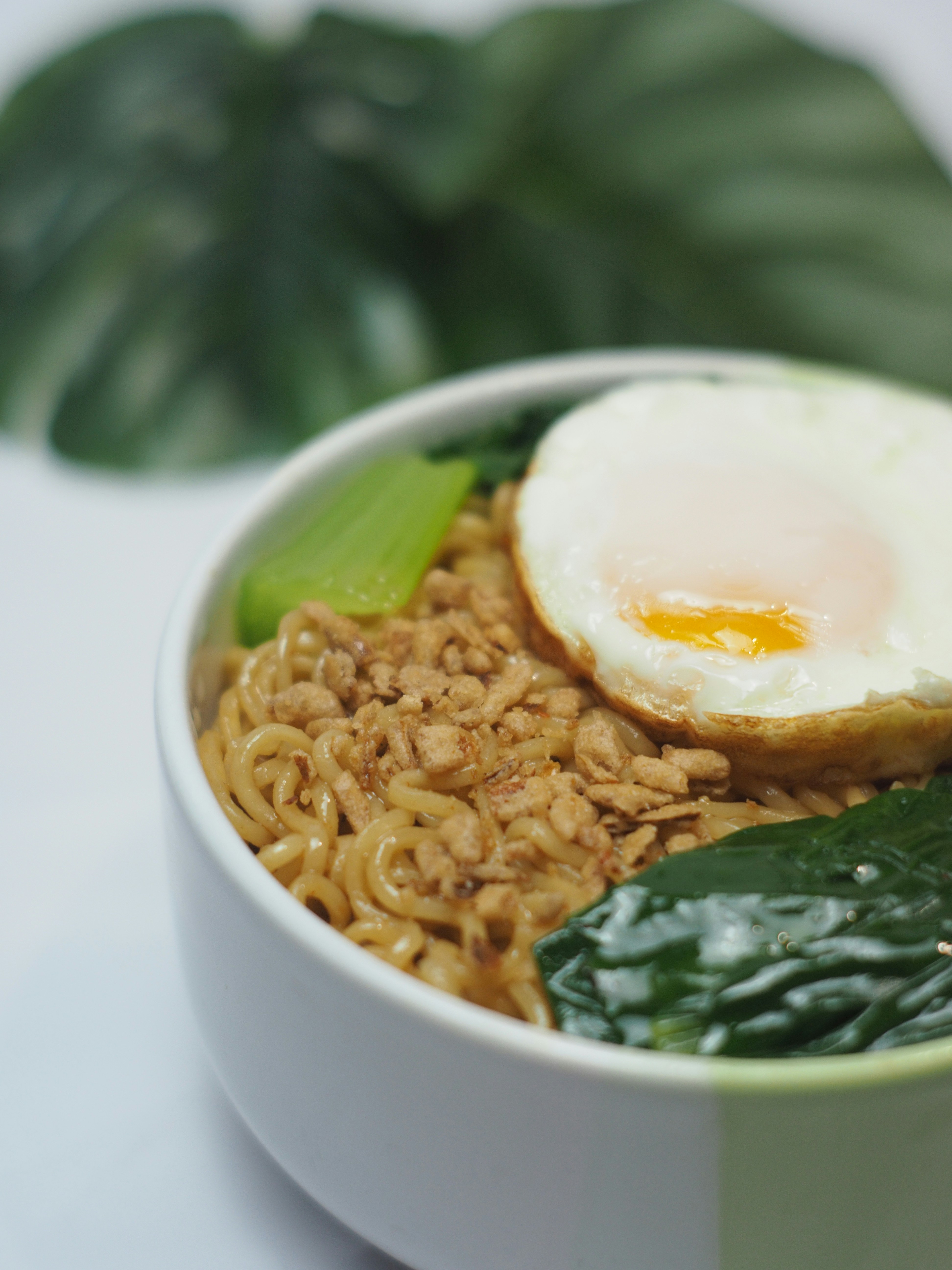 Bowl of noodles with fried egg and greens