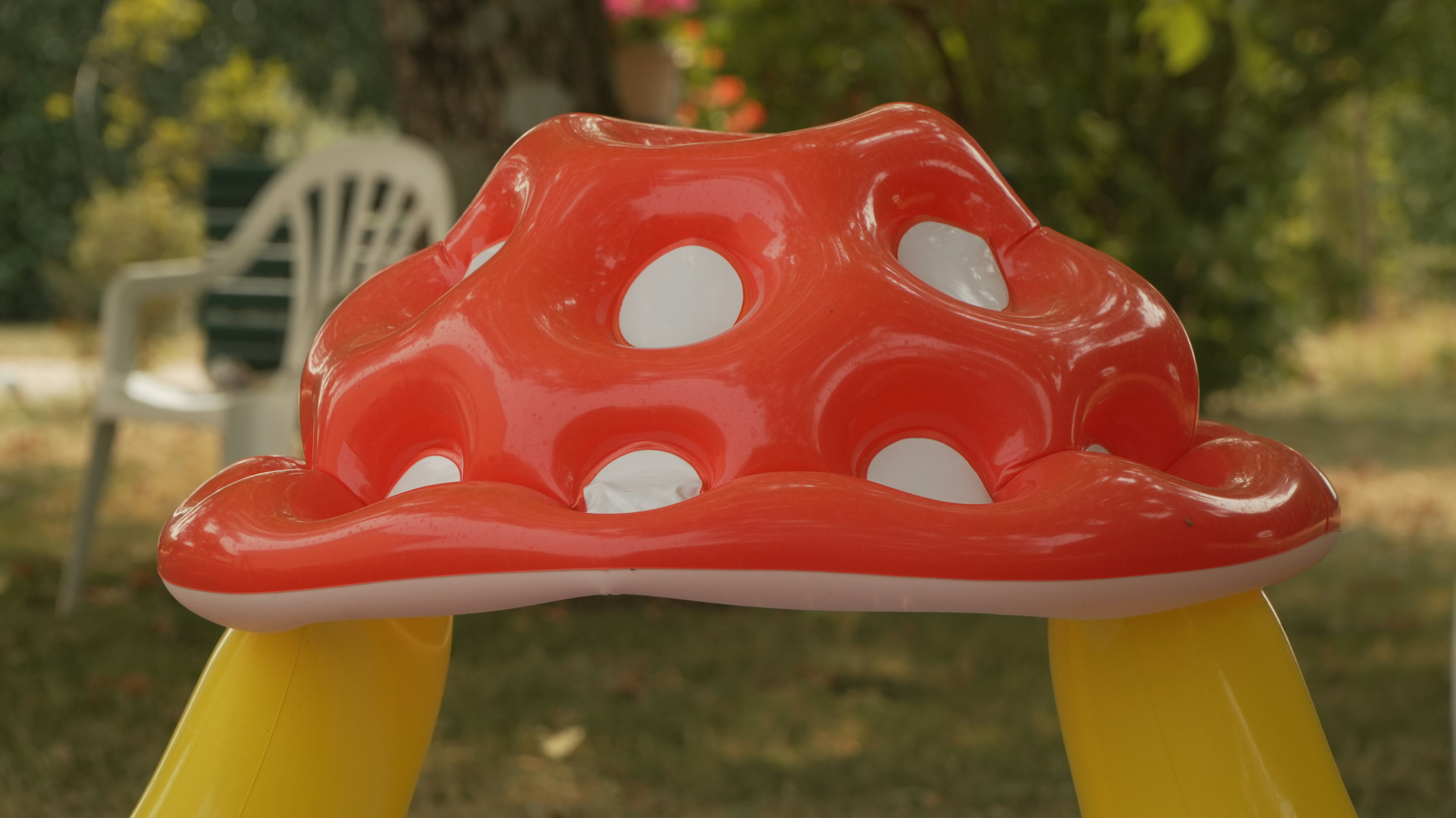 Red mushroom-shaped inflatable toy with white spots.