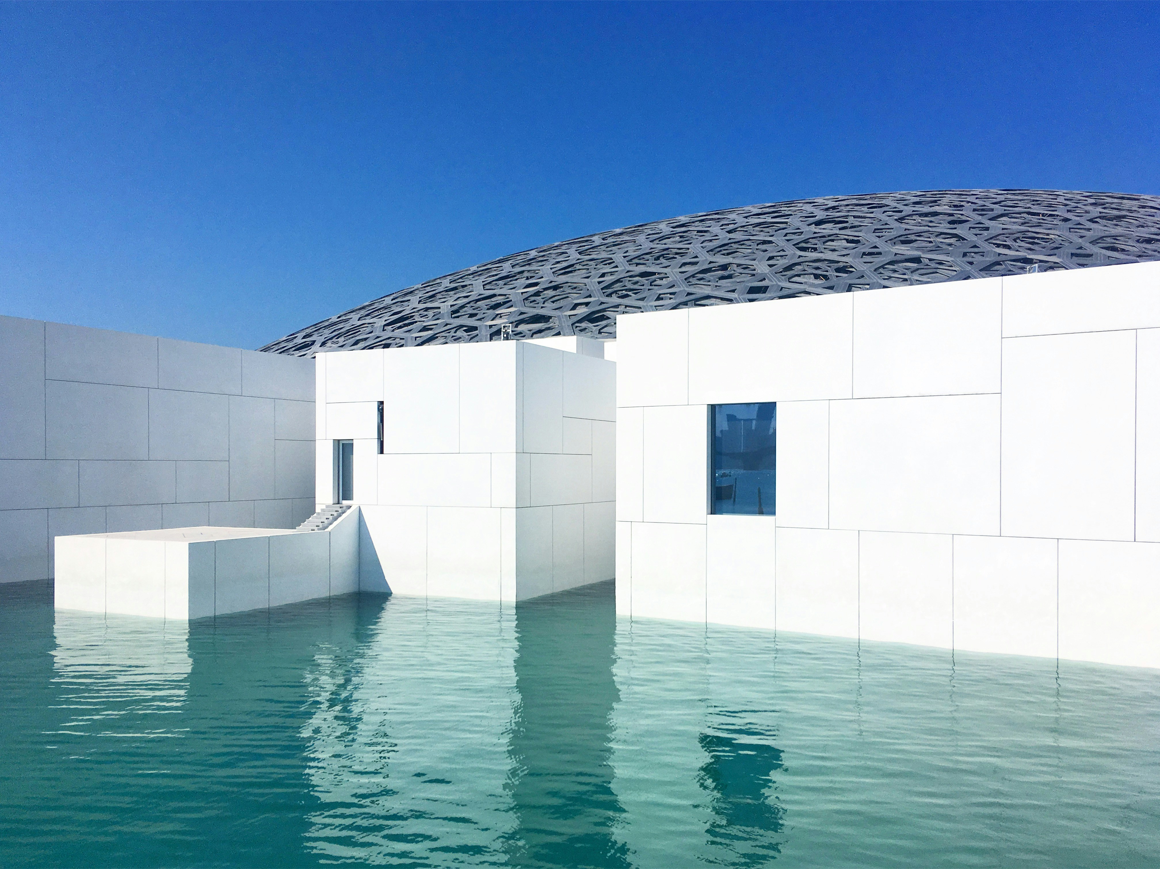 Modern white architecture reflected in calm water