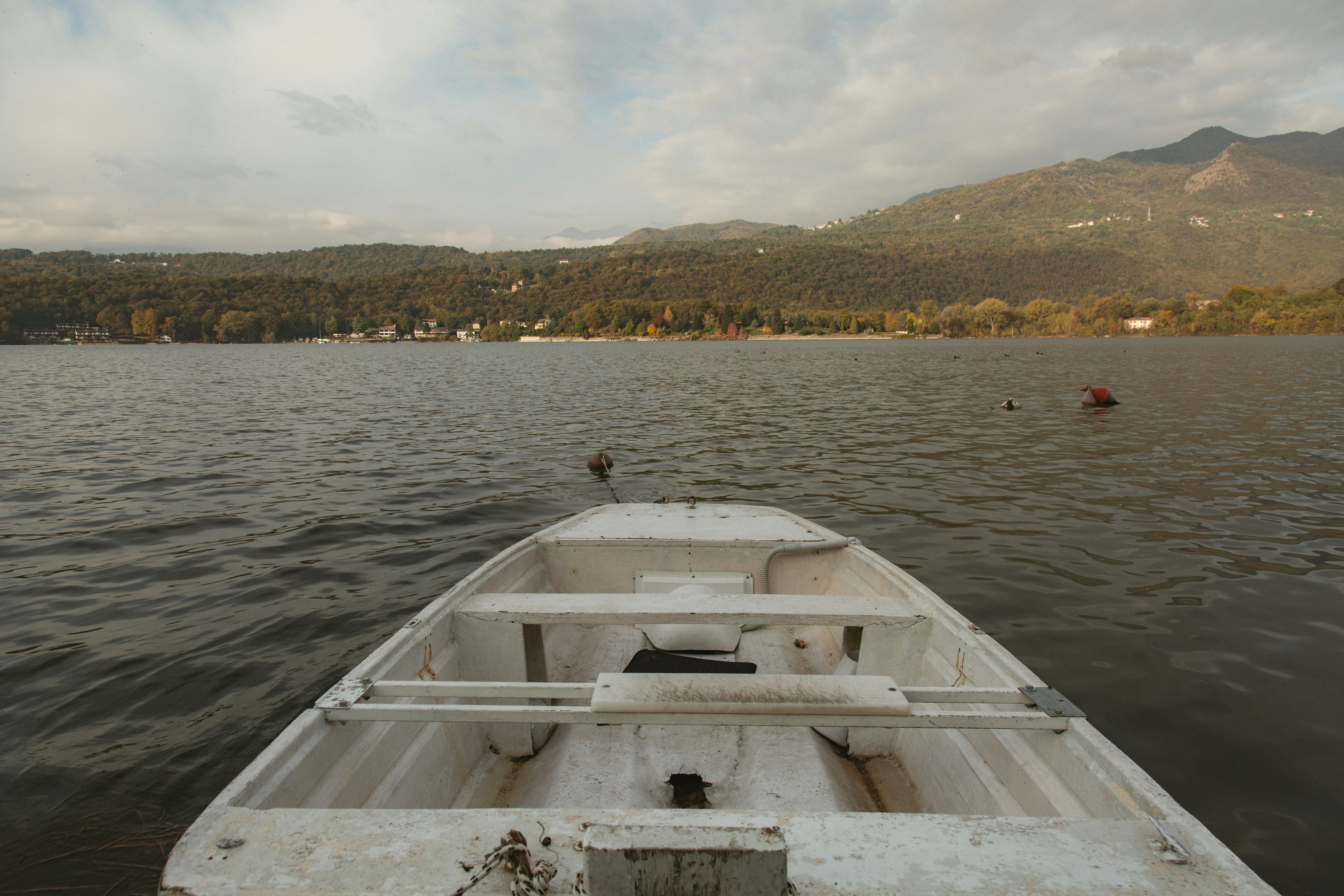 White boat on a calm lake with mountains