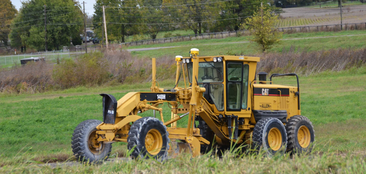 Motor grader shaping a dirt road on a construction site