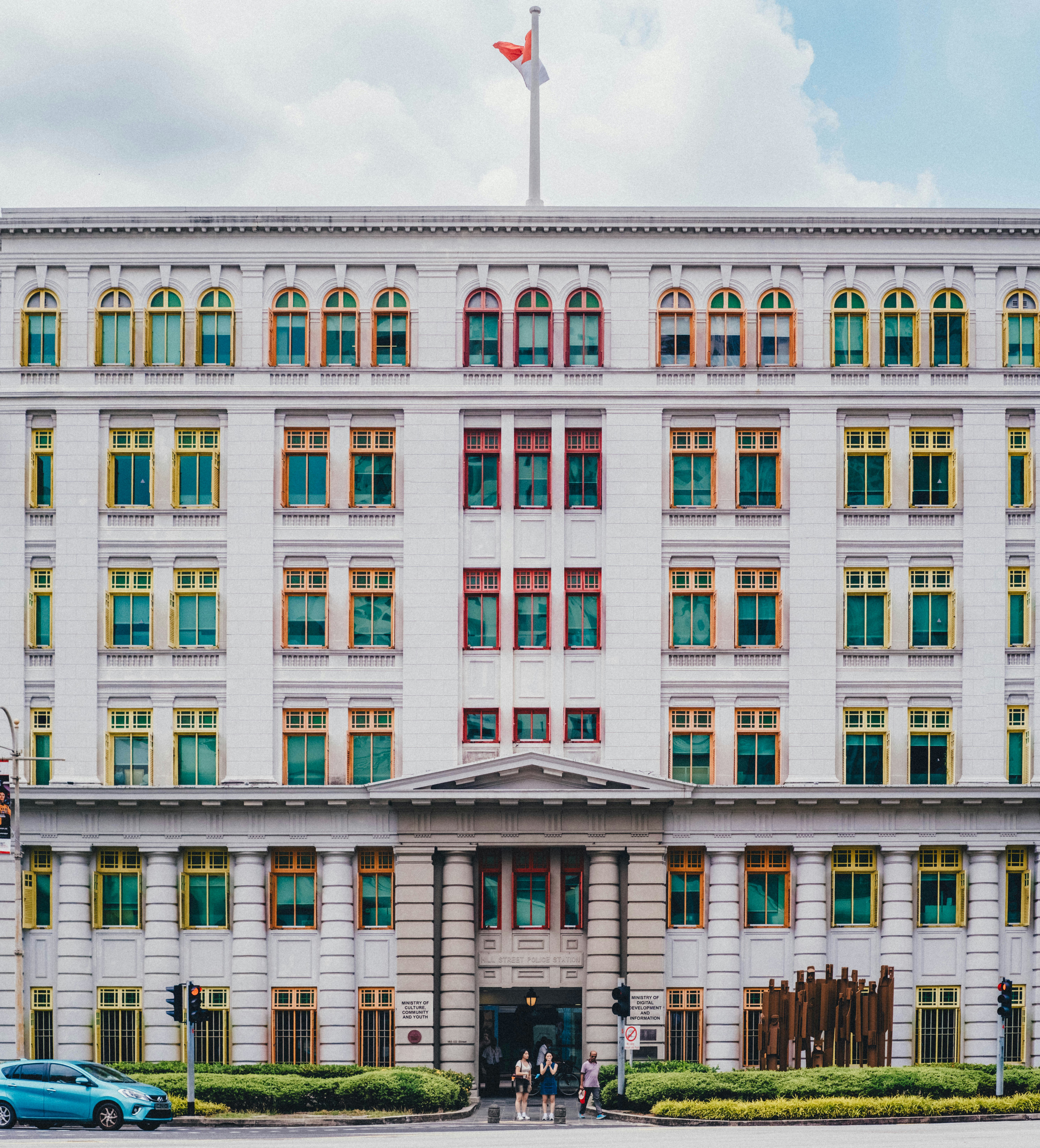 White building with colorful windows and a flag