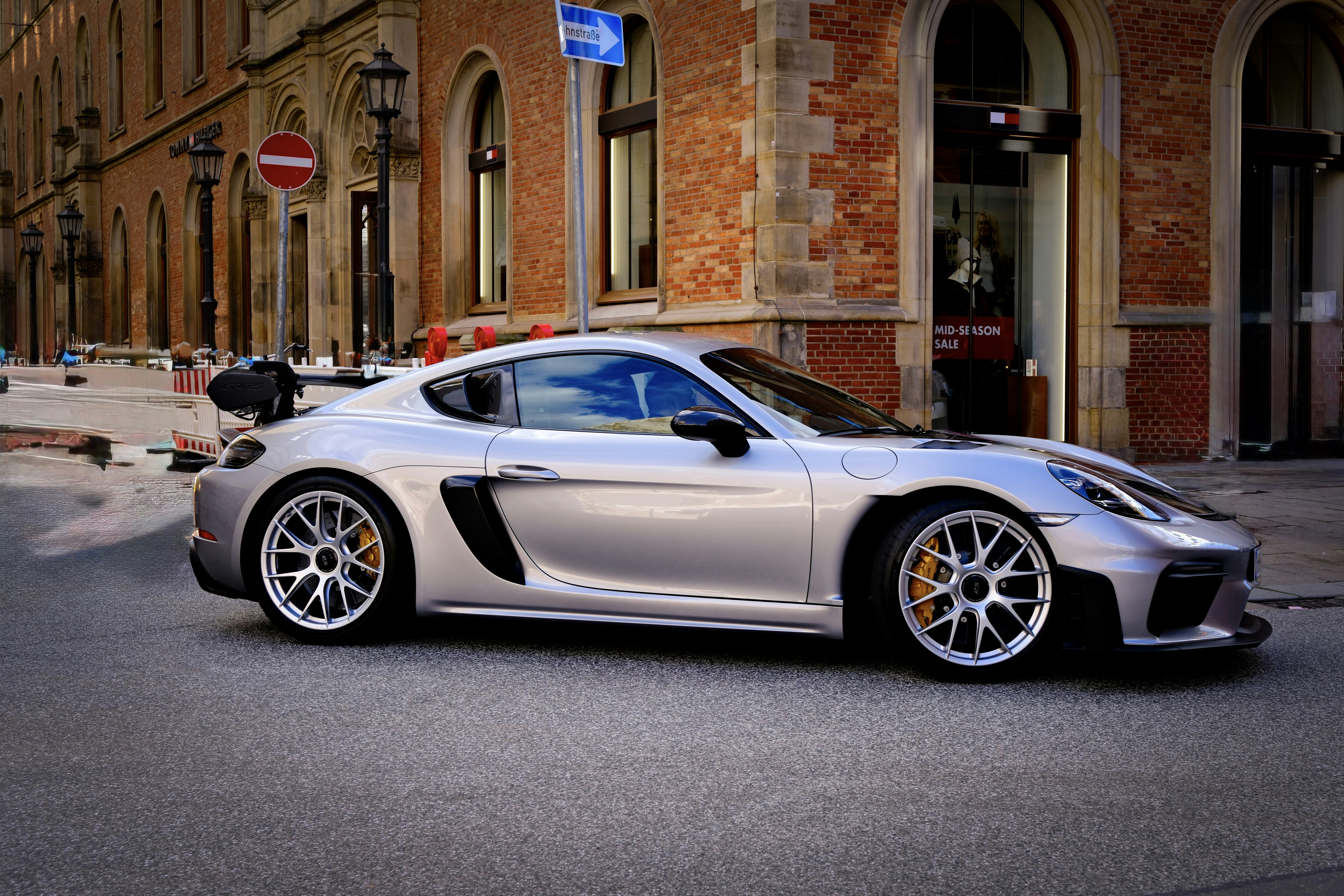 Silver sports car parked on a city street.