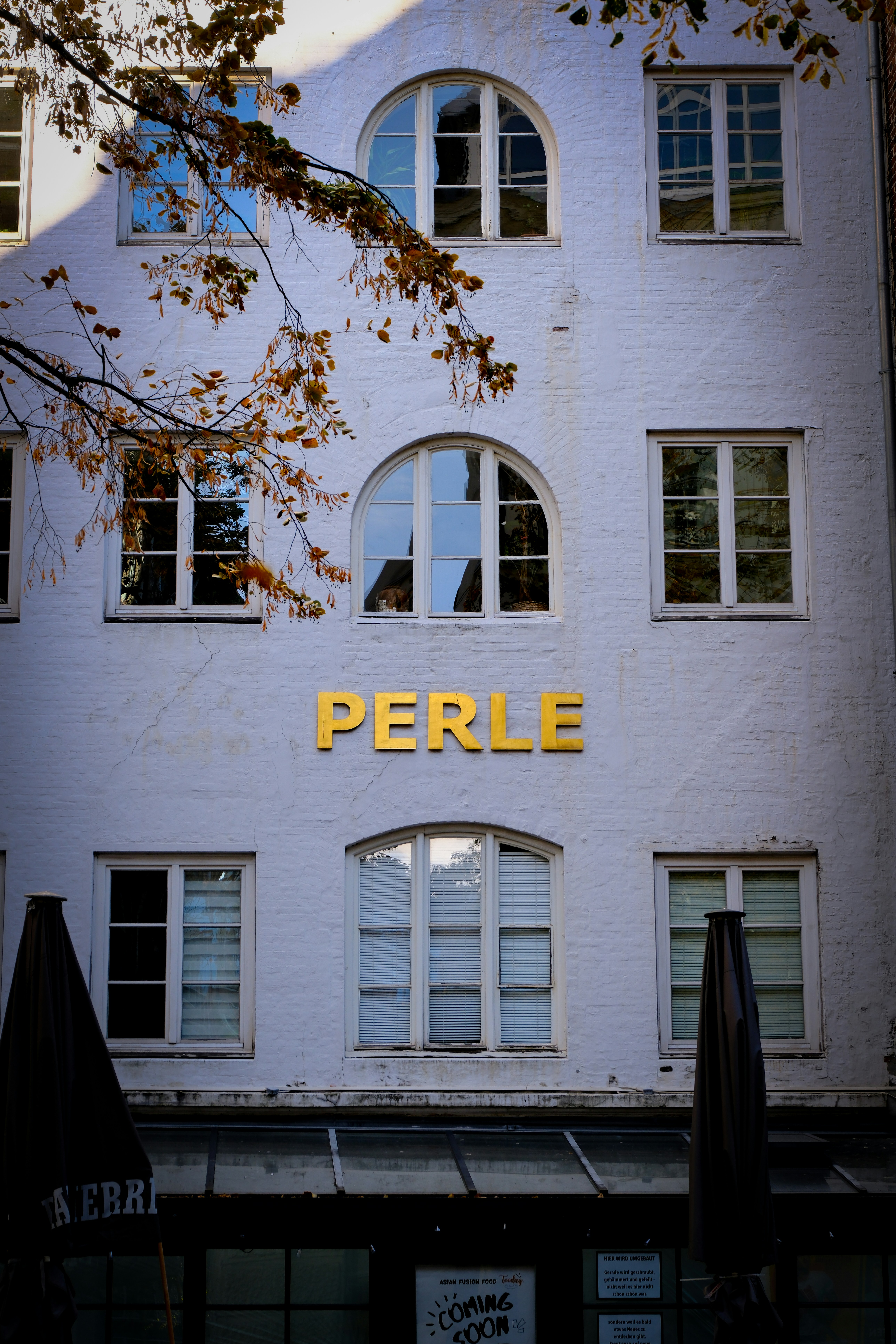 White building facade with gold lettering perle