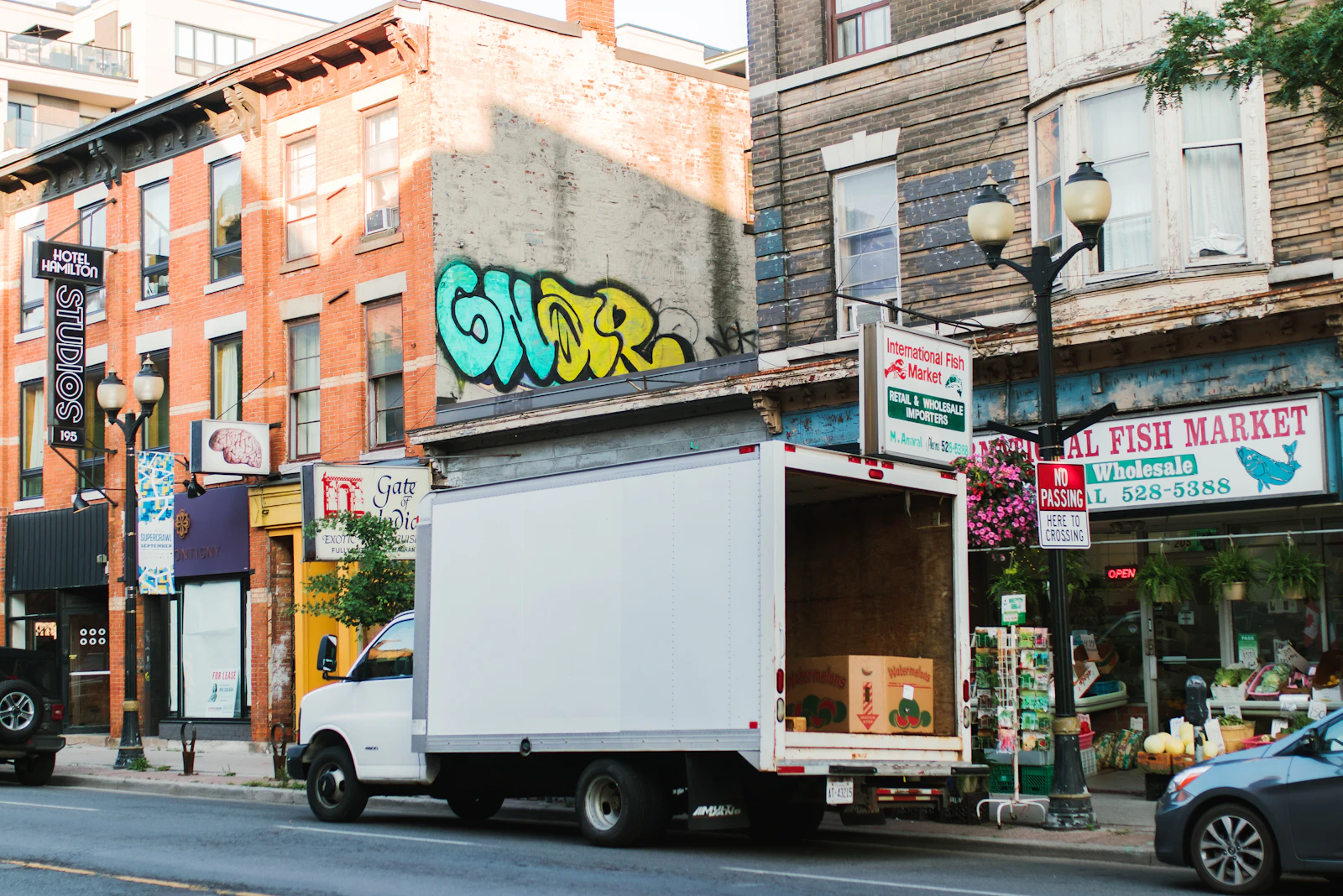 A white truck parked on a city street lined with shops