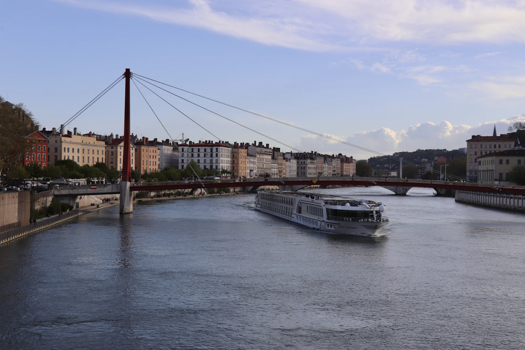 A modern river cruise ship sailing along the Saône through Lyon