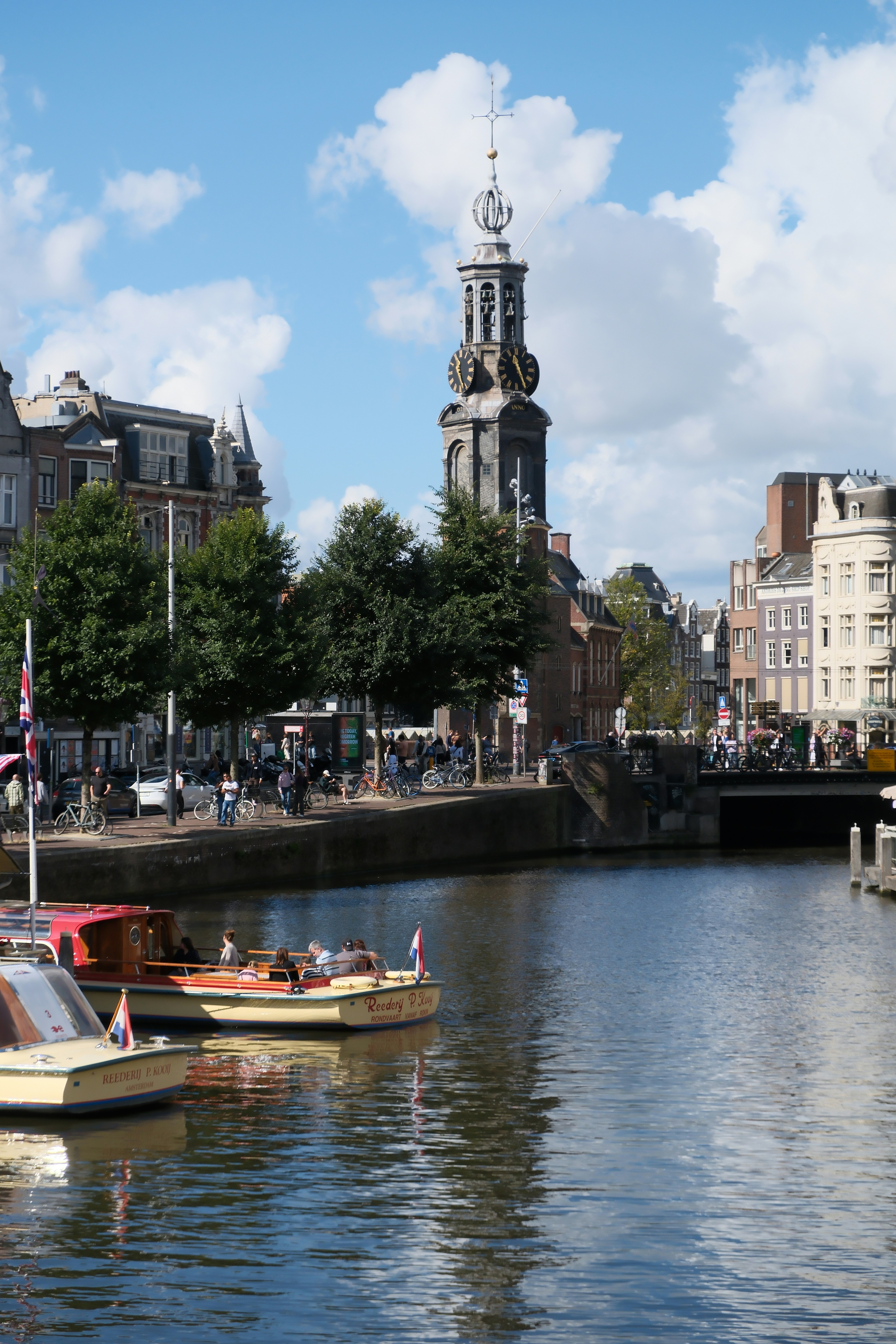 Boats on a canal with a clock tower building. - boats-on-a-canal-with-a-clock-tower-building-hImjYcXEe-o
