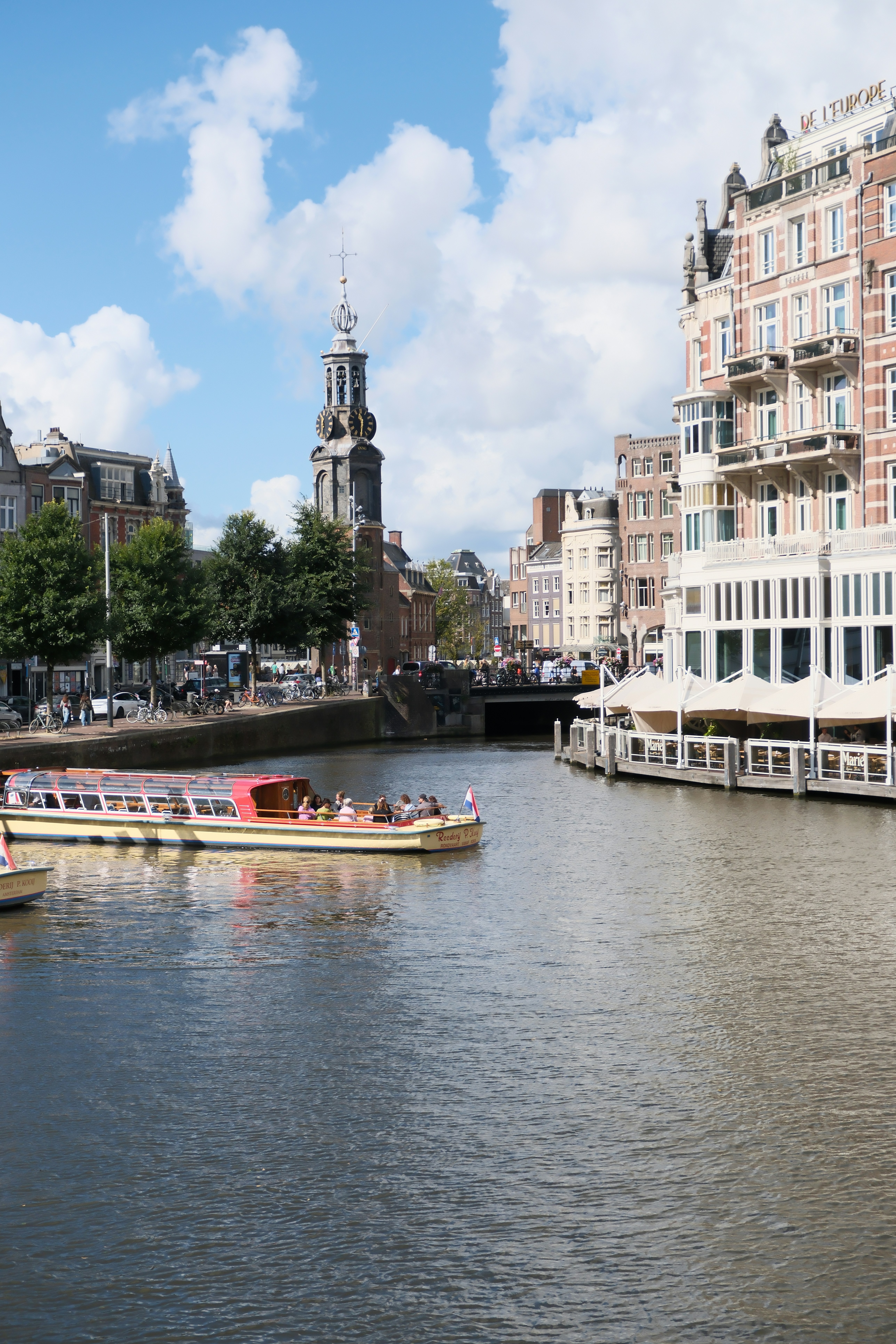 Tour boat on canal with historic buildings and tower - tour-boat-on-canal-with-historic-buildings-and-tower-Vxgsr8sXl80
