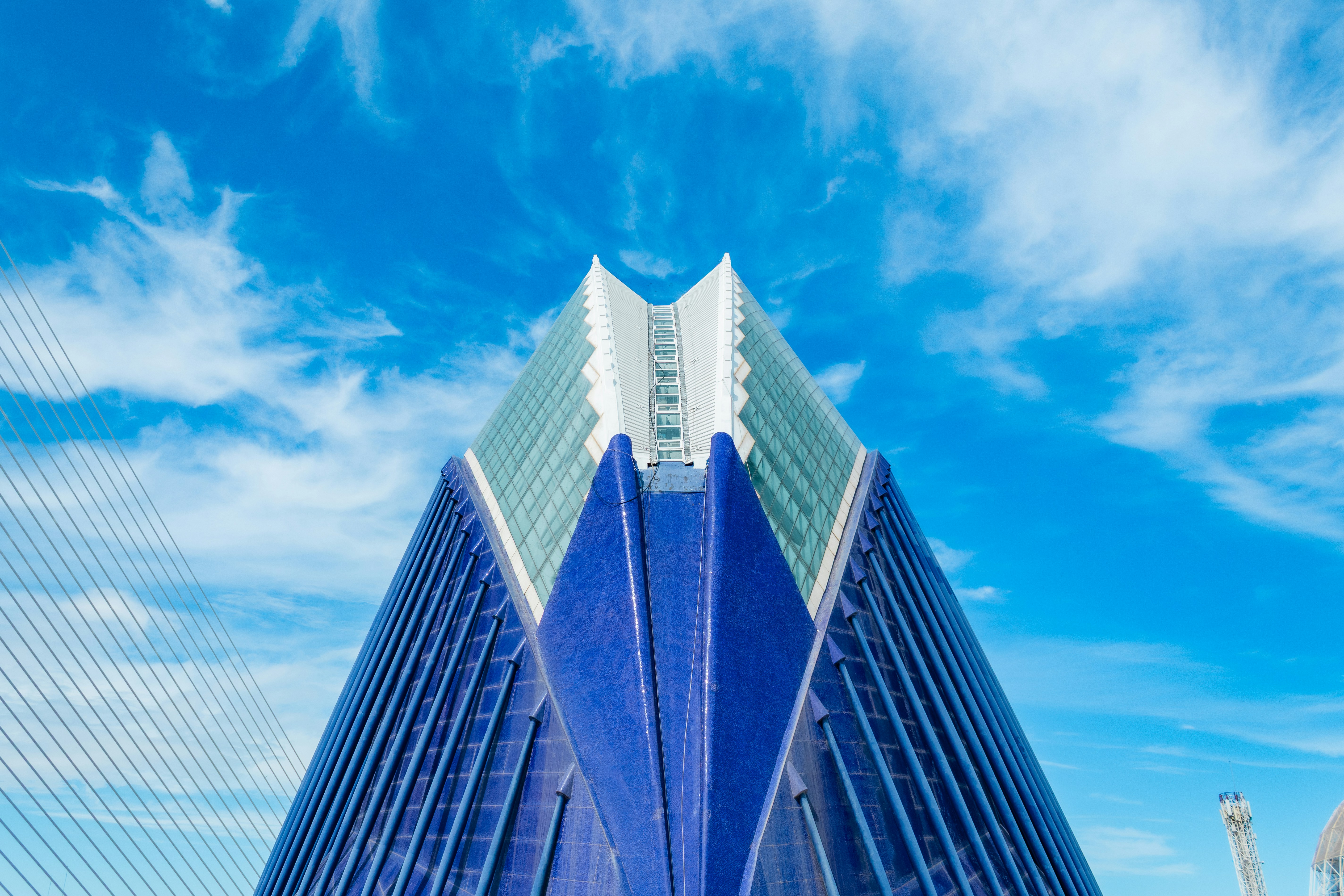 Modern building with blue and glass facade against sky.
