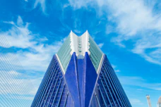 Modern building with blue and glass facade against sky.