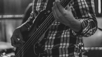 Musician playing a bass guitar in a band.