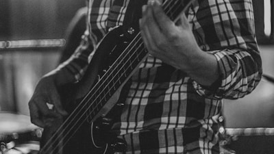 Musician playing a bass guitar in a band.