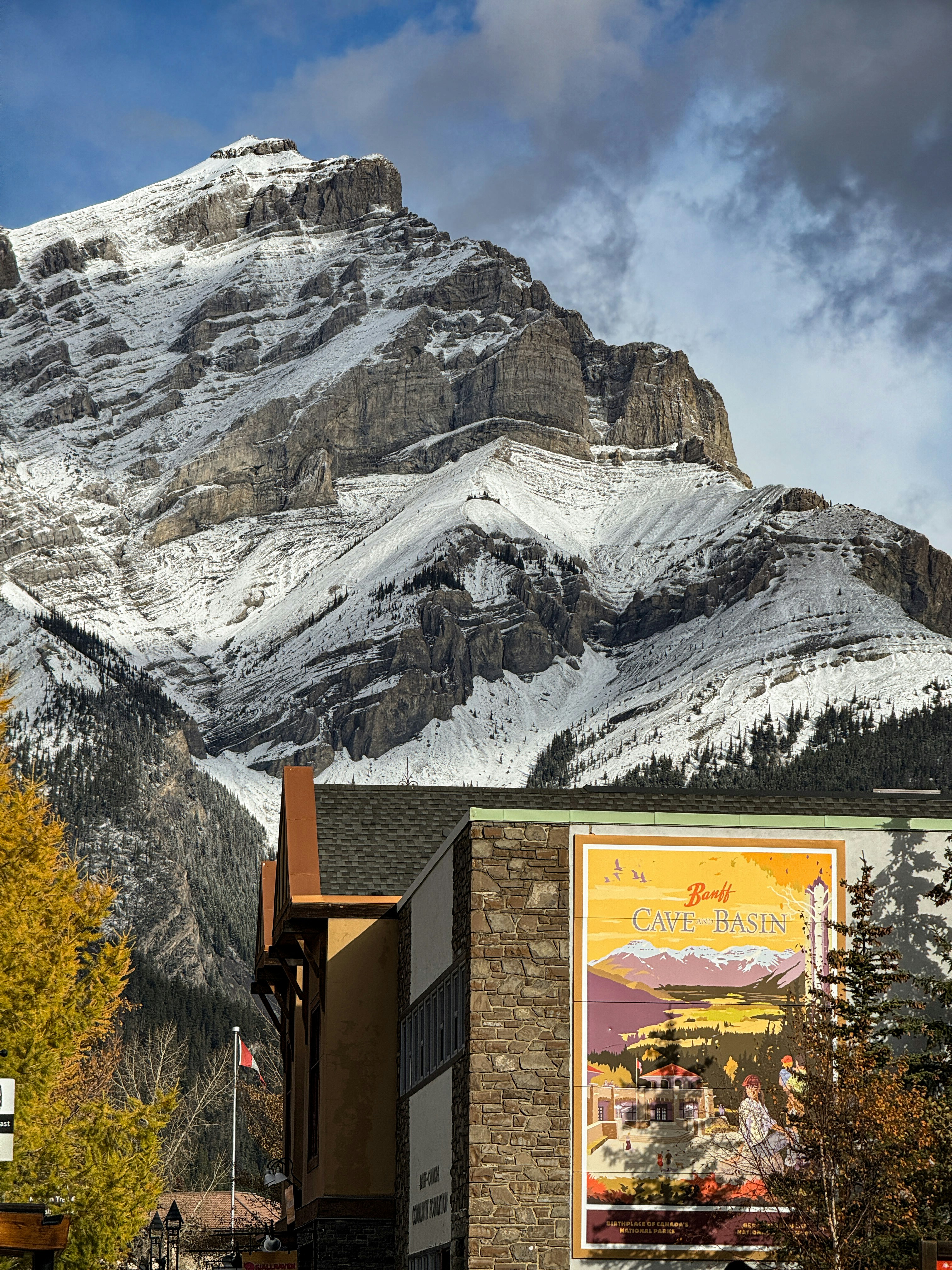 Snow-capped mountain overlooks buildings with mural.