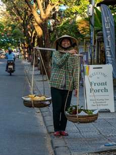 Woman carrying fruit on a shoulder pole