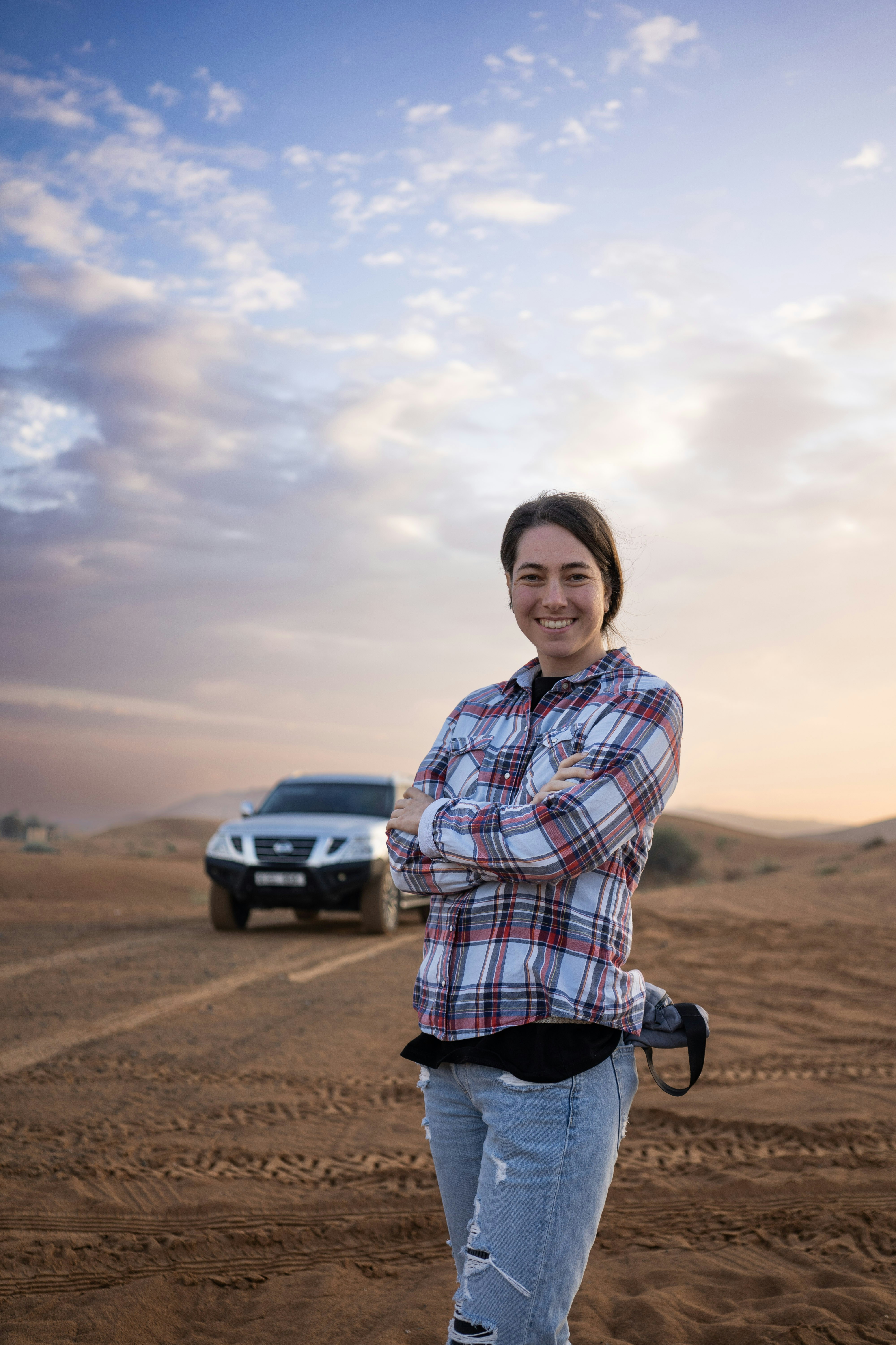 Donna in piedi nel deserto con fuoristrada.