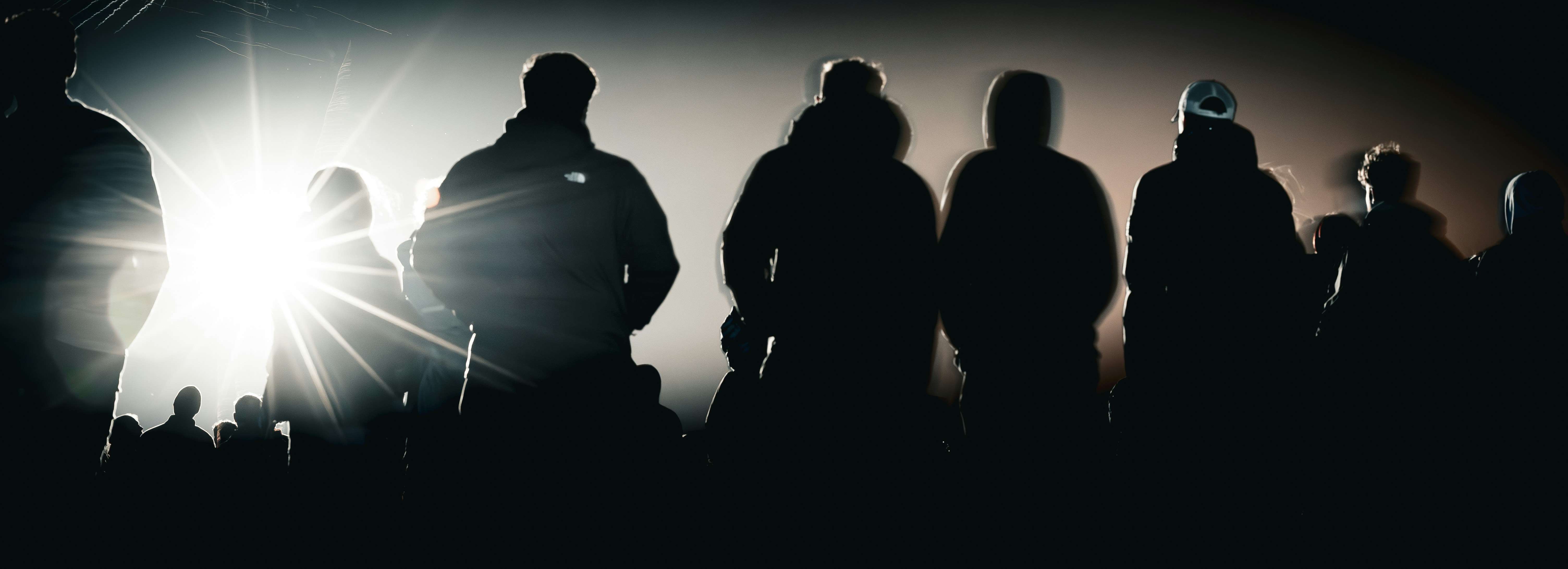 Silhouettes of people against a bright light