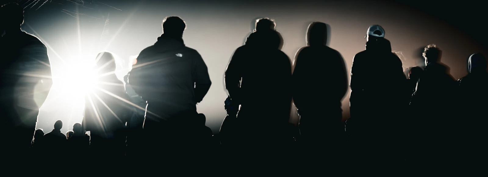 Silhouettes of people backlit against bright light