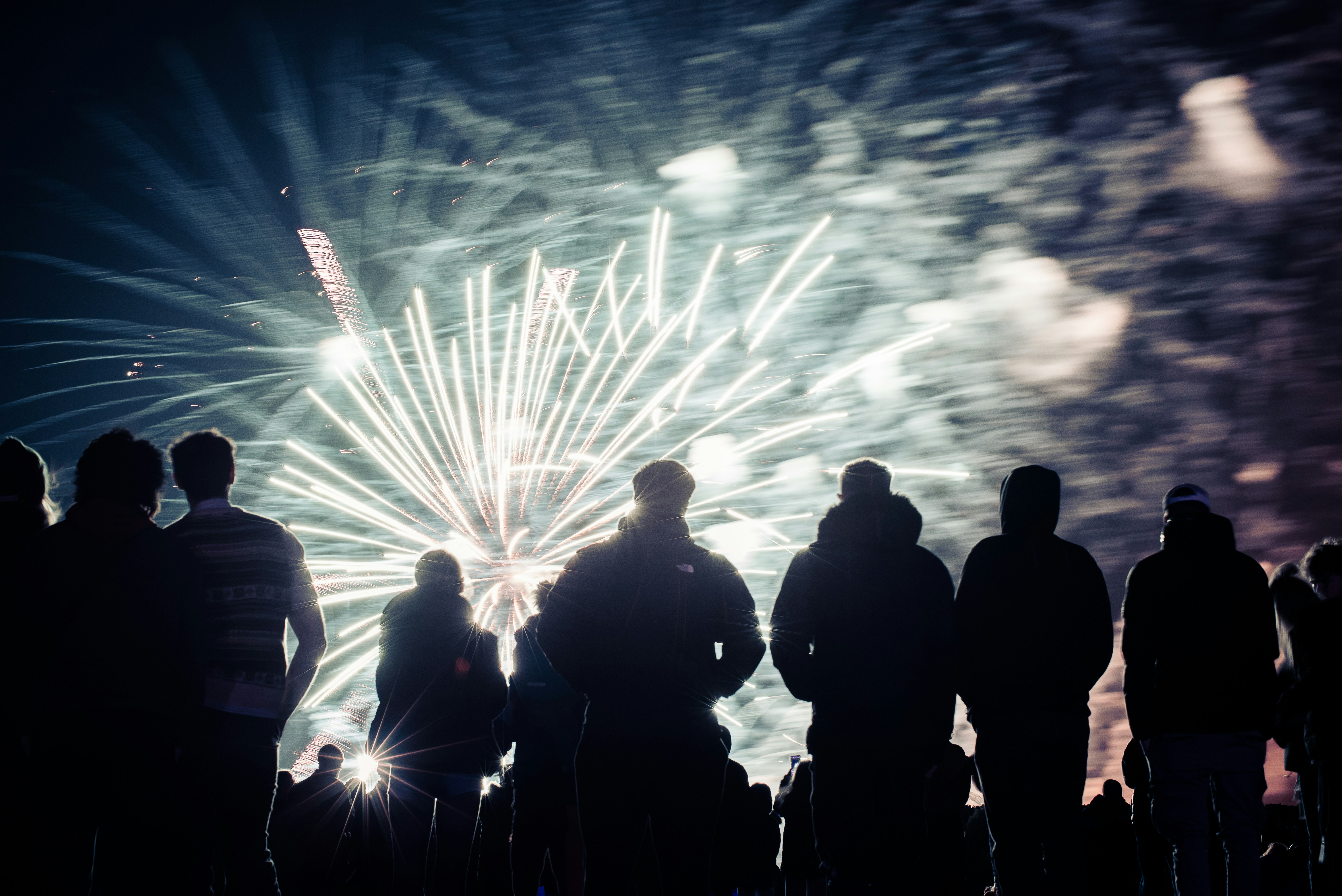 Silhouettes of people watching fireworks display