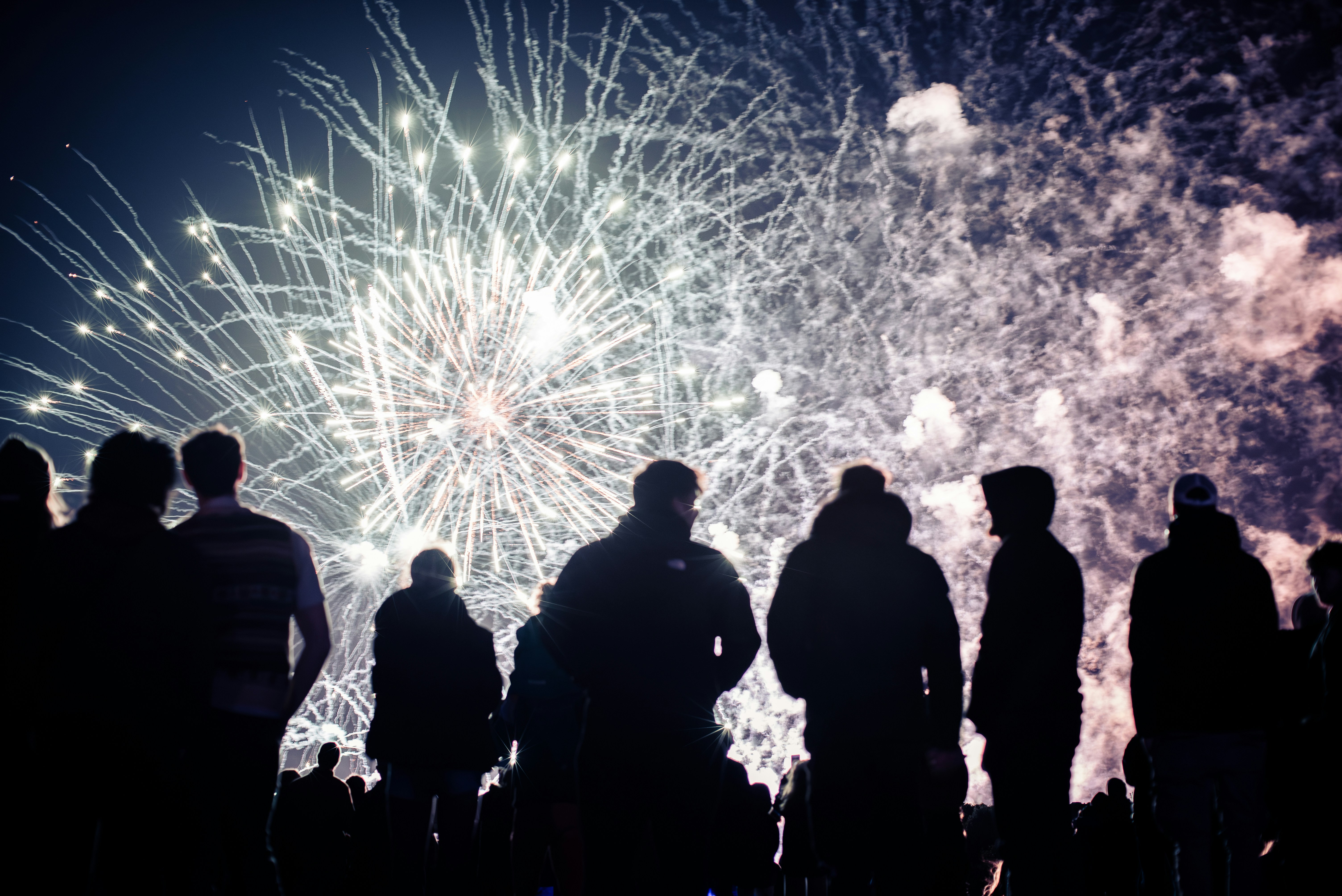 Crowd watches fireworks display at night