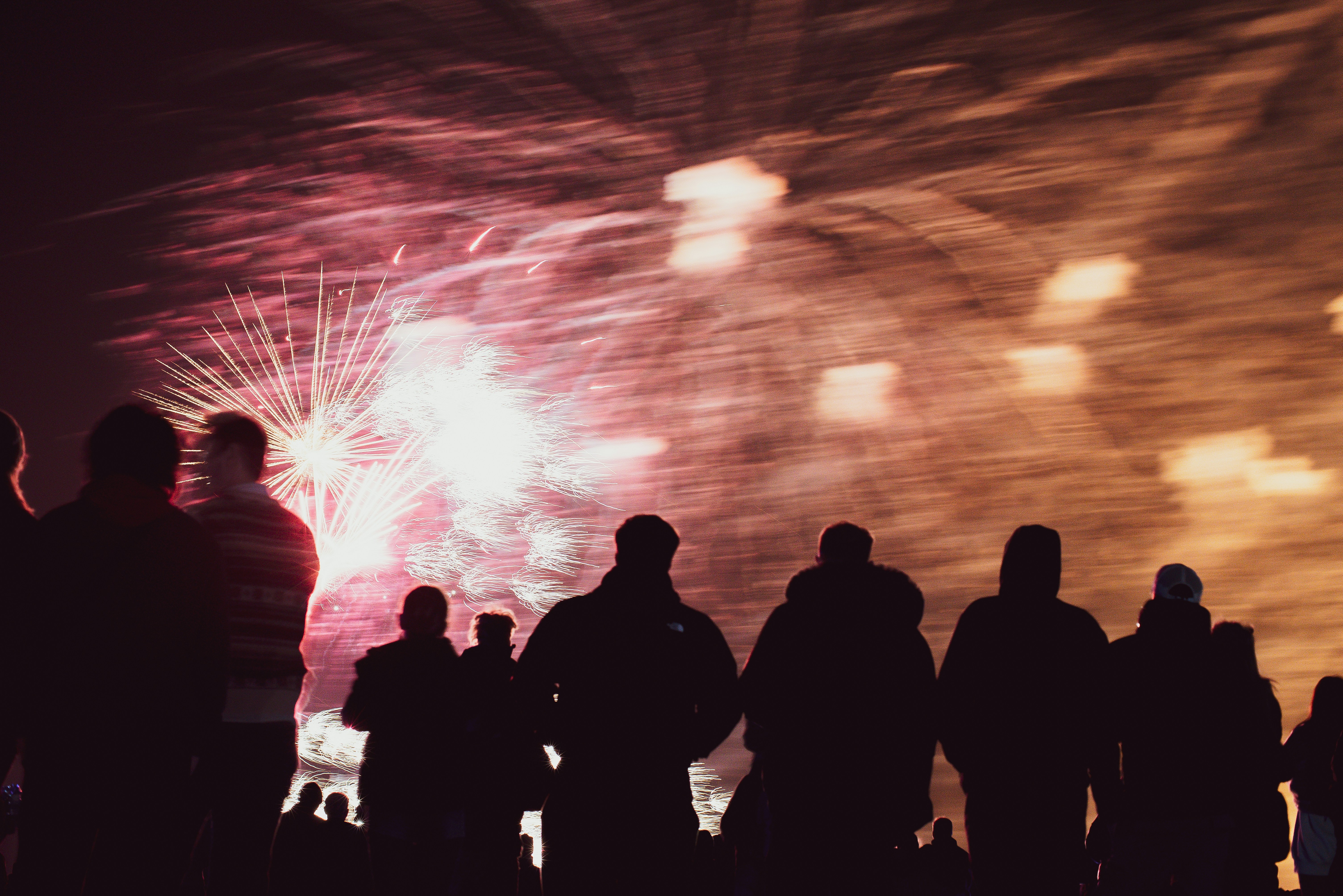 Silhouettes of people watching fireworks display