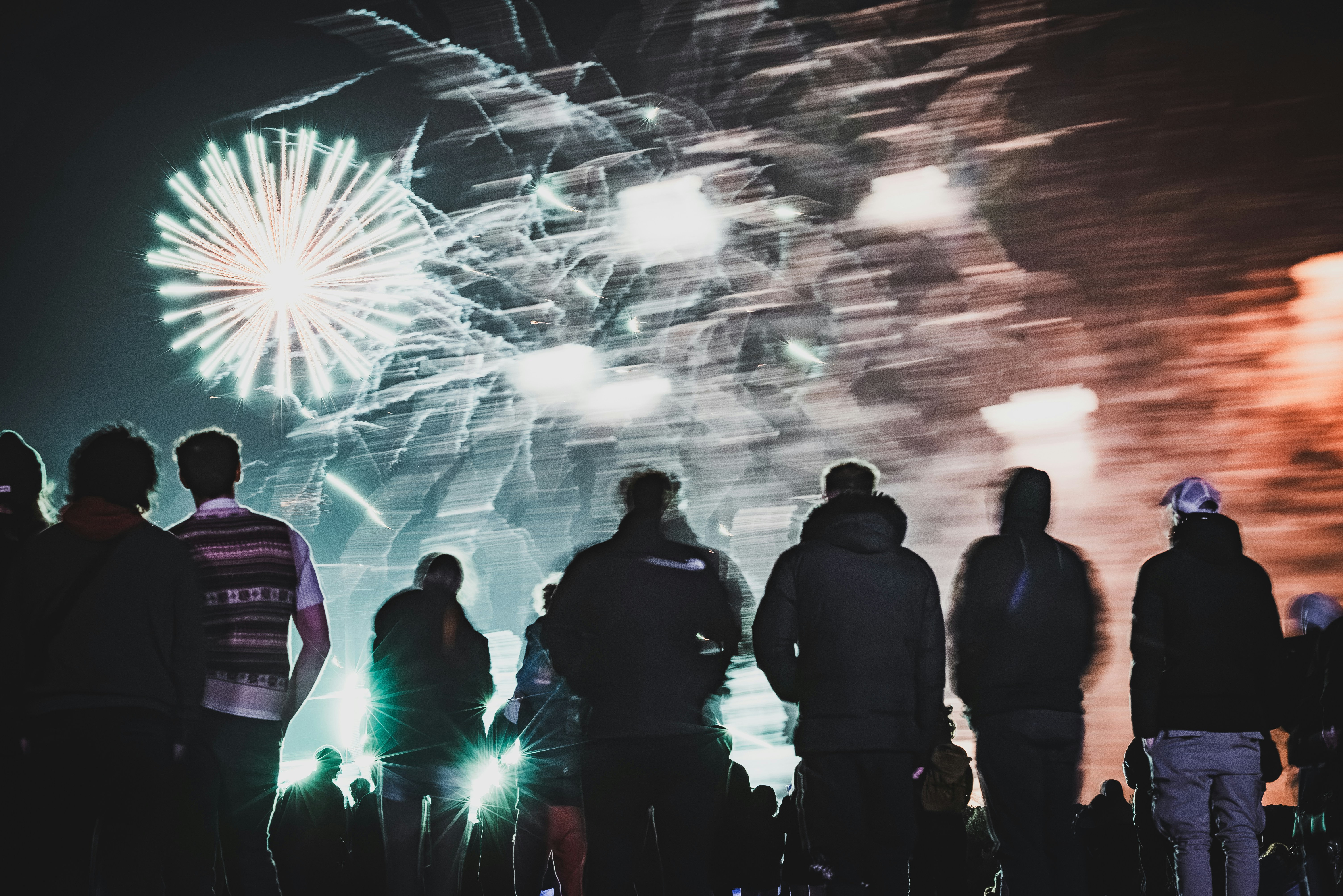 People watch fireworks light up the night sky