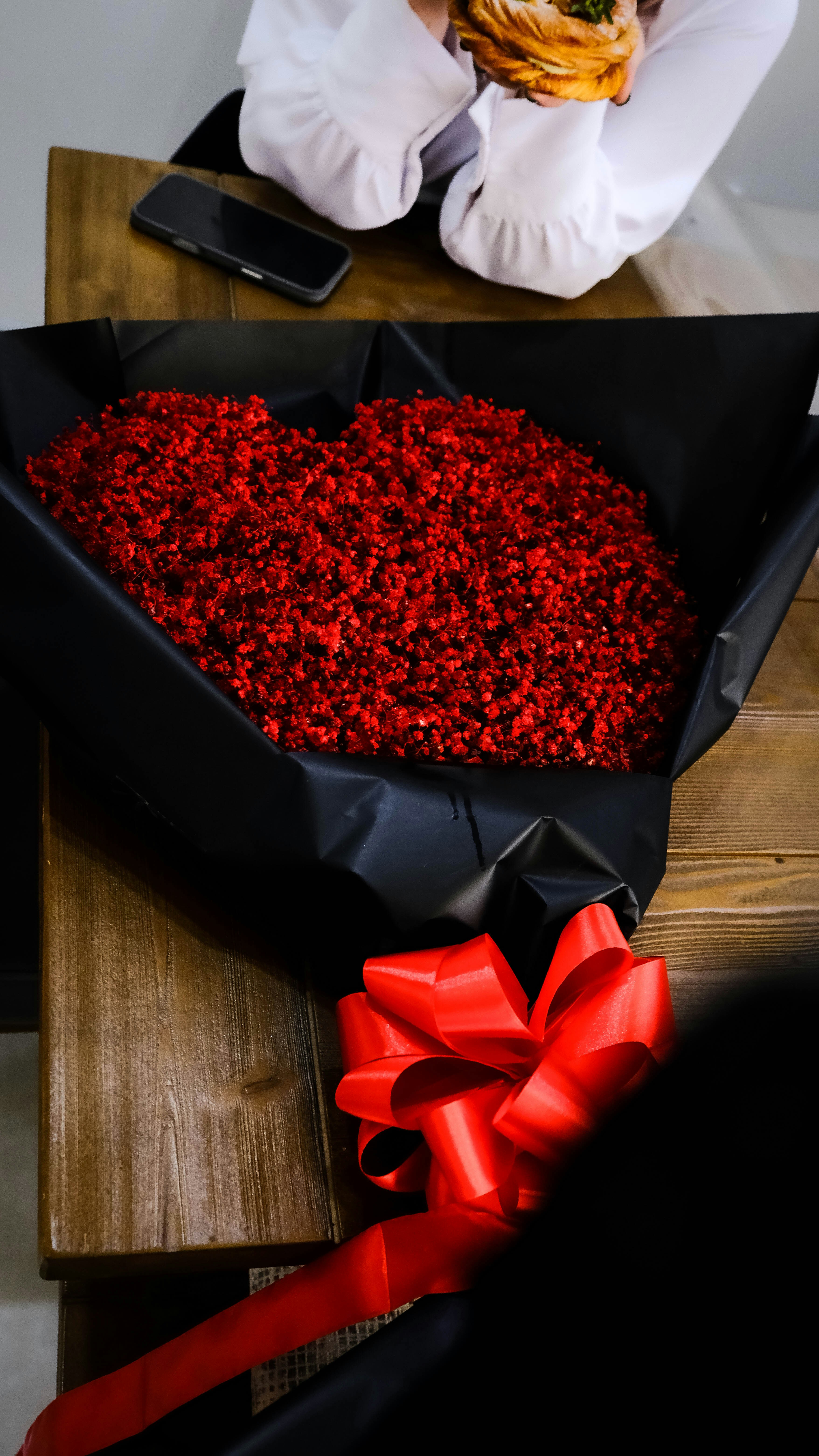 A large bouquet of red flowers with a red bow
