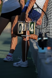 Tennis players with a scoreboard showing 0-0-4