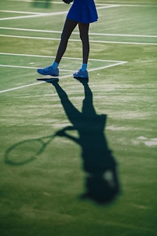 Shadow of a tennis player with racket on court