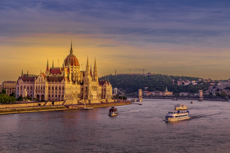 Budapest Parliament building illuminated at sunset from the Danube River